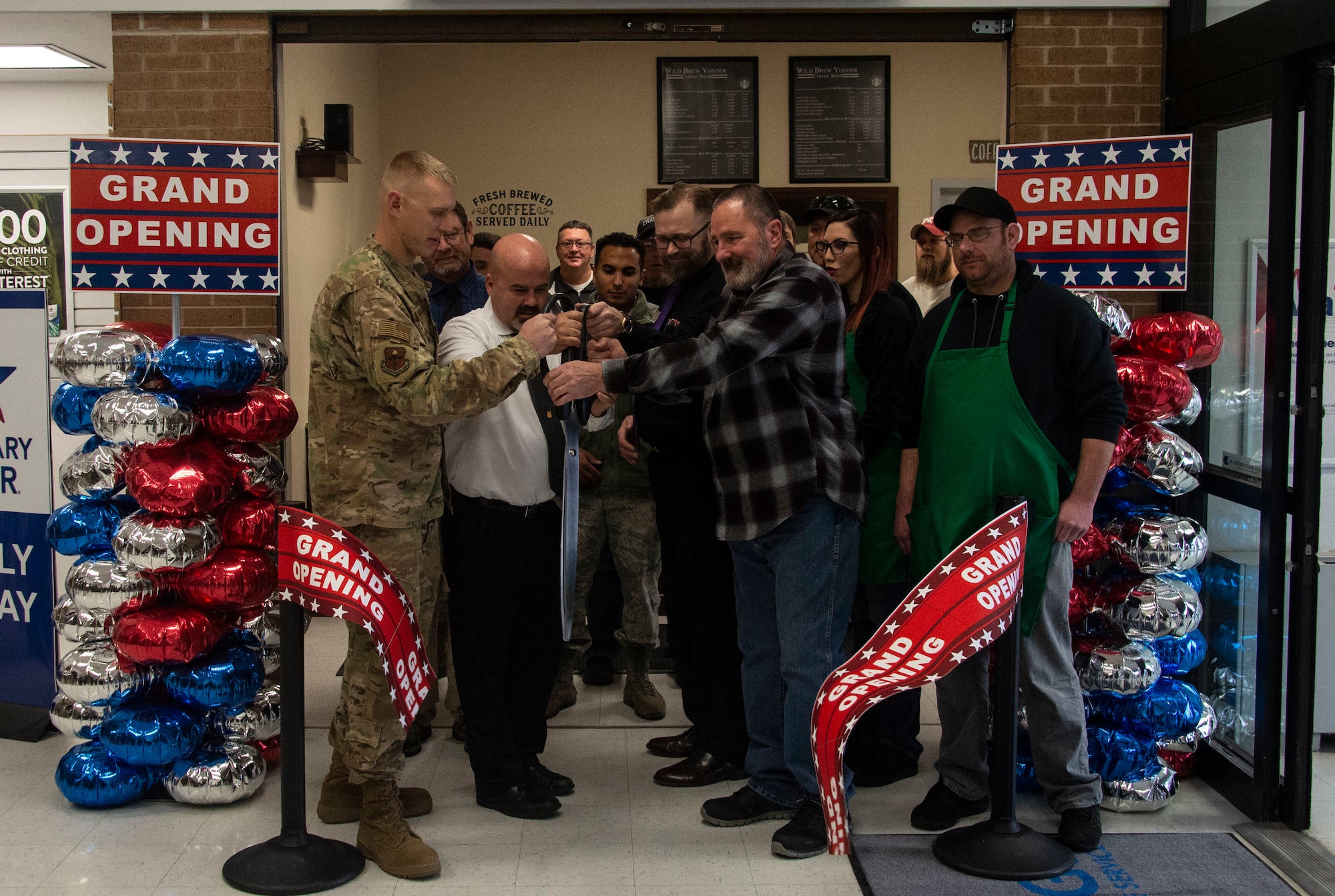 Members of the 97th Air Mobility Wing responsible for helping build the new Wild Brew Yonder coffee shop cut the grand opening ribbon, Feb. 29, 2019 at Altus Air Force Base, Okla.