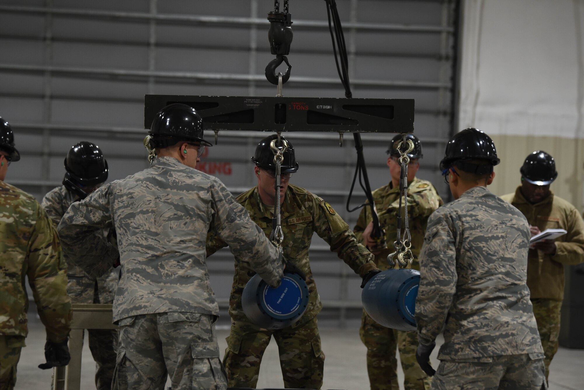 A team of Airmen work together to bring three small-diameter bombs onto a conveyer during the qualifying round of the second annual Air Force Combat Operations Competition on Ellsworth Air Force Base, S.D., Feb. 5, 2019. The competition is Air Force-wide and is used to determine the best of the best in munitions operations. (U.S. Air Force photo by Airman John Ennis)