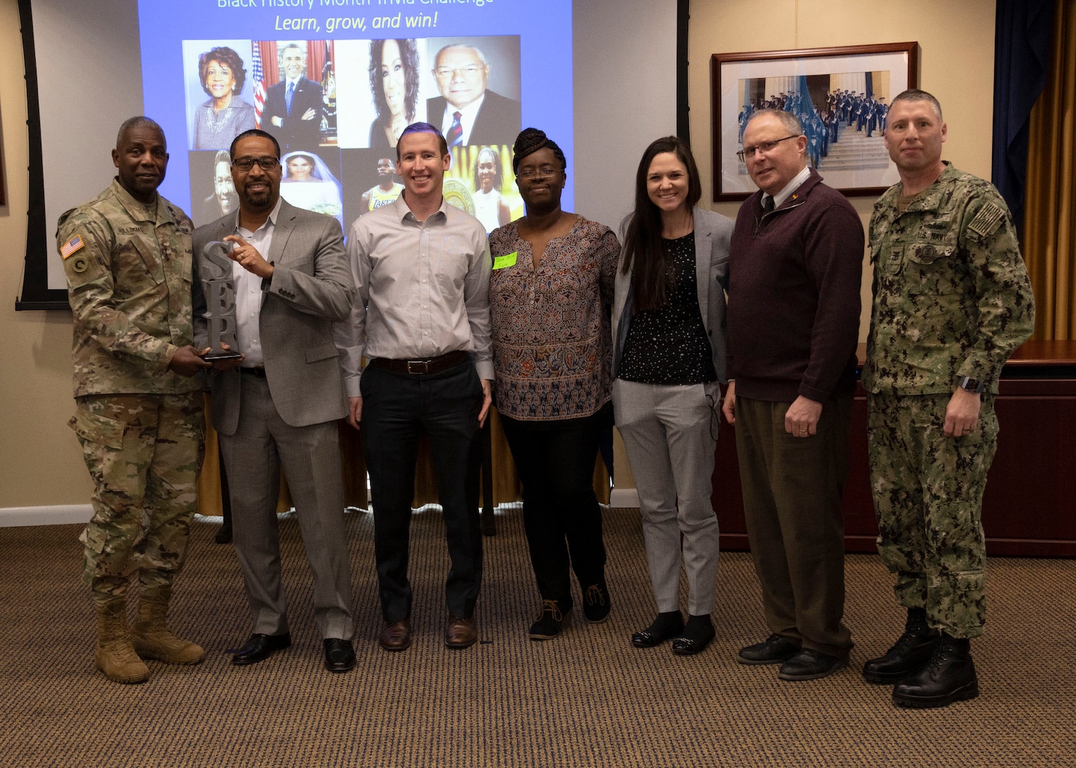 DLA Director Army Lt. Gen. Darrell Williams (left) and Navy Command Master Chief Shaun Brahmsteadt (far right) present the 5-person DLA team with a special emphasis program award for their win during the Black History Month trivia challenge, Feb. 27.