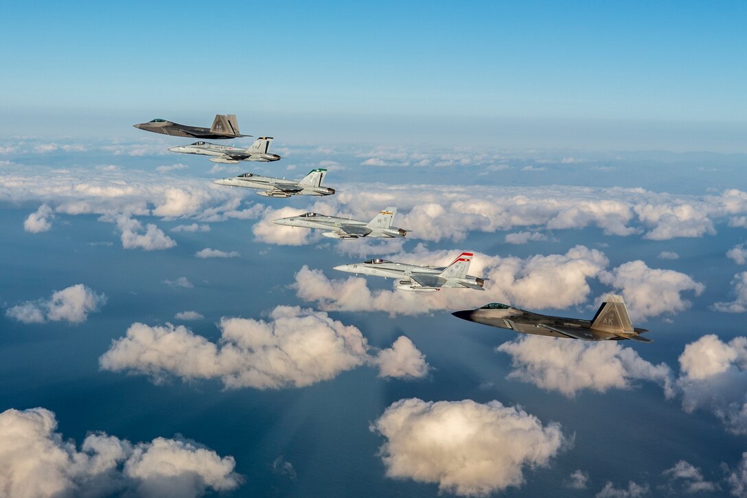 Four F/A-18 Hornets from Marine Aircraft Group (MAG) 11, 3rd Marine Aircraft Wing (MAW), fly in close formation over the Southern California coast with two F-22 Raptors from 3rd Operations Group, Elmendorf Air Force Base, Alaska, Feb. 6.  The flight commemorated joint training achieved during exercises Winter Fury 2019 and Patriot Grizzly 2019, which focused on joint large-force tactical air integration against simulated high end air-to-air and surface-to-air threats, further honing Marine and Air Force 4th and 5th generation tactics and interoperability.