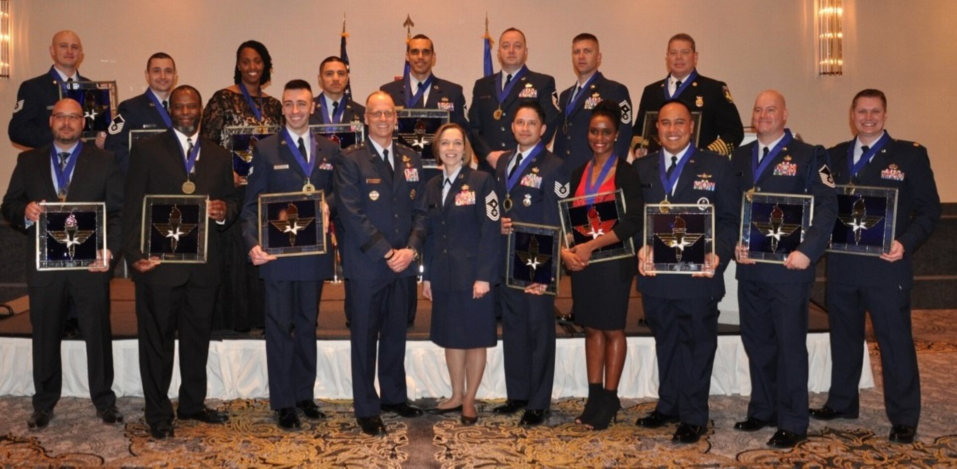 Winners of the 2018 Air Education and Training Command Outstanding Airmen of the Year awards stand with Maj. Gen. Mark Weatherington (third from left) and command chief of AETC, Chief Master Sgt. Juliet Gudgel (fourth from left) during a ceremony in Orlando, Fla., Feb. 26, 2019. A total of 21 Airmen were recognized at the event and move on to the the Air Force-level competition.