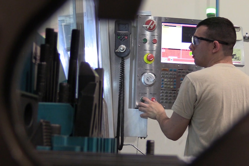 An airman operates a milling machine
