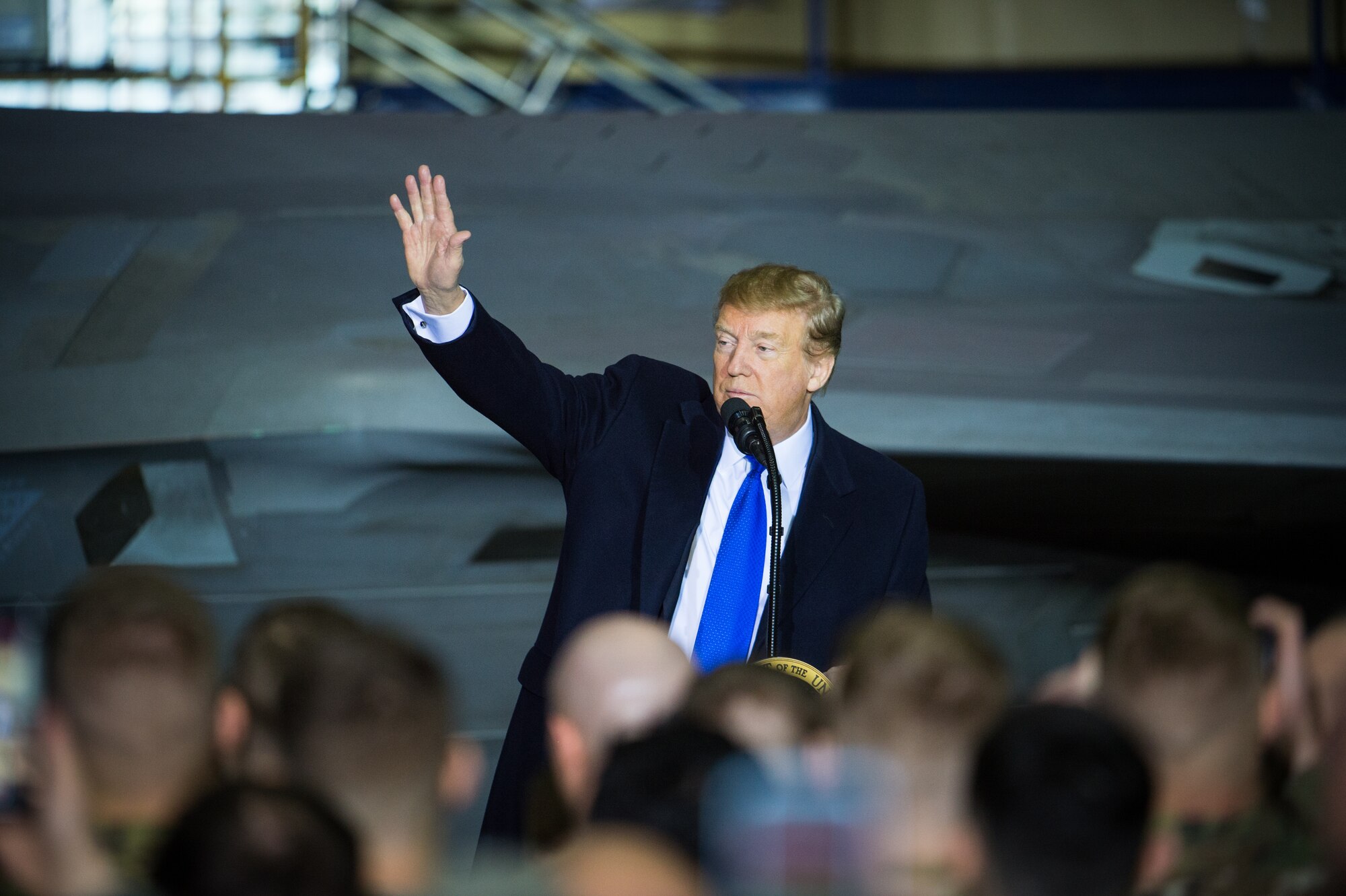 President Donald Trump waves to more than 100 Airmen, Sailors, Soldiers, Marines and Coast Guardsmen at Joint Base Elmendorf-Richardson, Alaska, Feb. 28, 2019. The president was at the base to meet with service members after returning from a summit in Hanoi, Vietnam.  His plane refueled before continuing to Joint Base Andrews, Maryland.