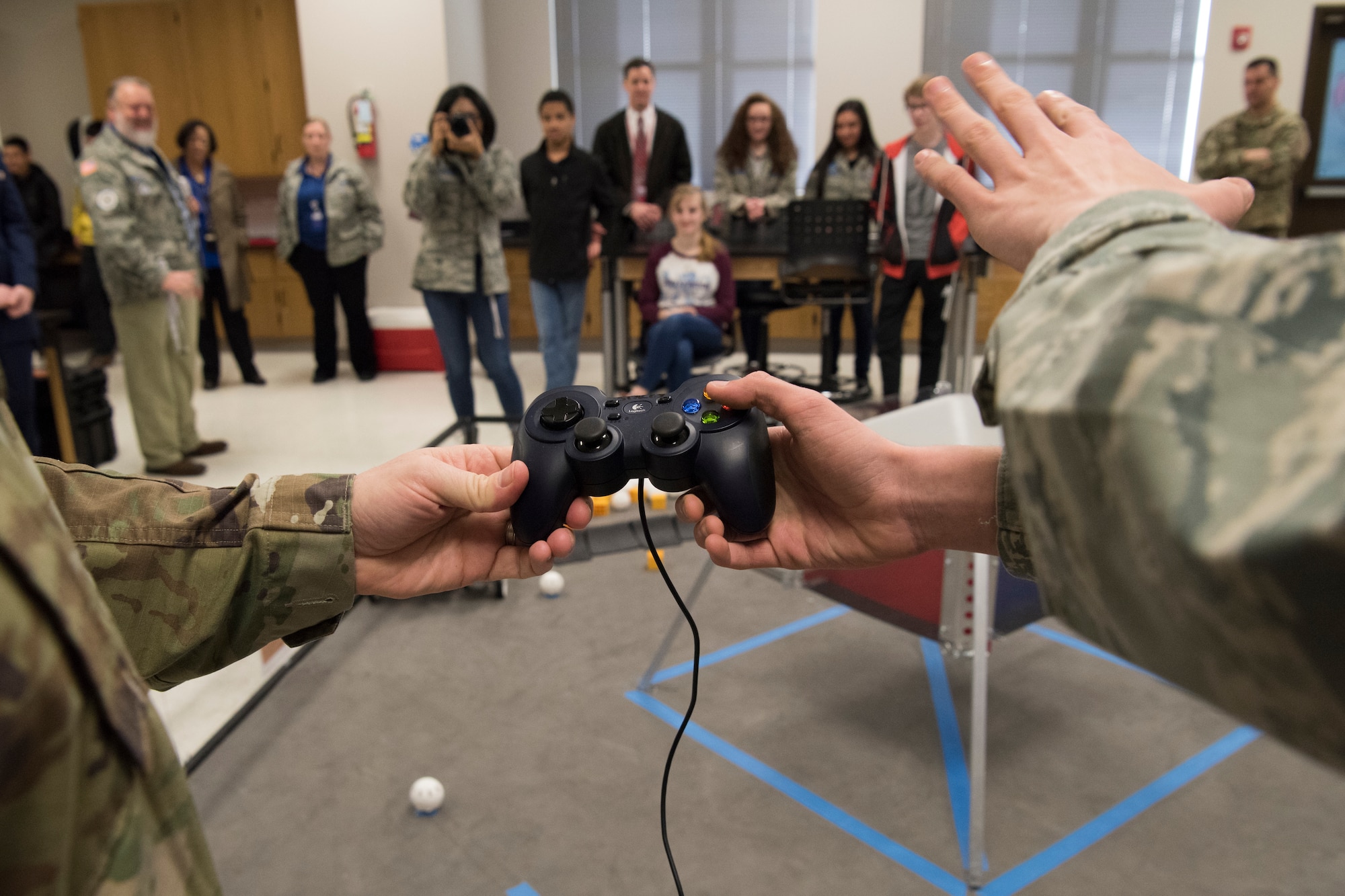 A Bots in Blue club member shows Col. Robert W. Trayers Jr., Air Force Recruiting Service vice commander, how to drive their robot during a visit to Virginia Allred Stacey Junior/Senior High School Feb. 13, 2019, at Joint Base San Antonio-Lackland, Texas.