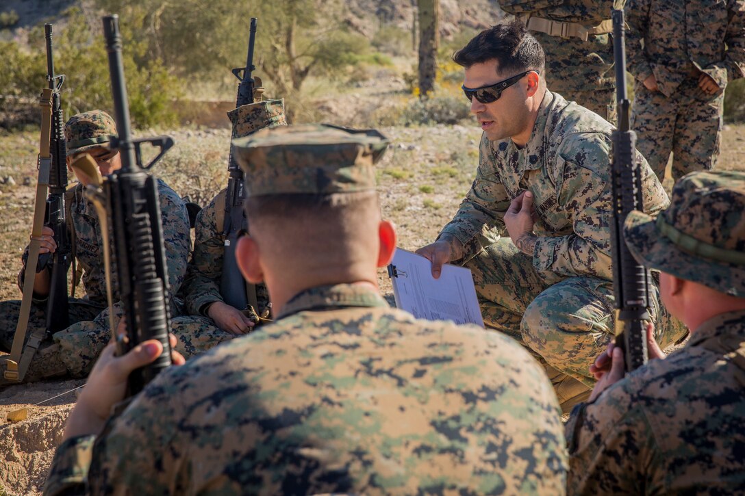 U.S. Marines and Sailors assigned to Marine Corps Air Station (MCAS) Yuma's Search and Rescue (SAR) unit talk about the SAR unit's mission to non-commisioned officers (NCOs) from MCAS Yuma, Ariz., Feb. 7, 2019 as a part of "Operation Backbone." Operation Backbone is a quarterly unit exercise meant to strengthen the warrior's spirit in the non-commisioned officers (NCOs) and promote cohesion between them. The exercise consisted of a hike with the Headquarters and Headquarters Squadron (H&HS)  commanding officer and acting sergeant major, several classes, and a warriors night. Classes included simulated room clearing training, terrain model training, improvised explosive devices (IED) training, and the Family Advocacy Program on station sent out a representative to talk to the NCOs about leadership. (U.S. Marine Corps photo by Cpl. Isaac D. Martinez)