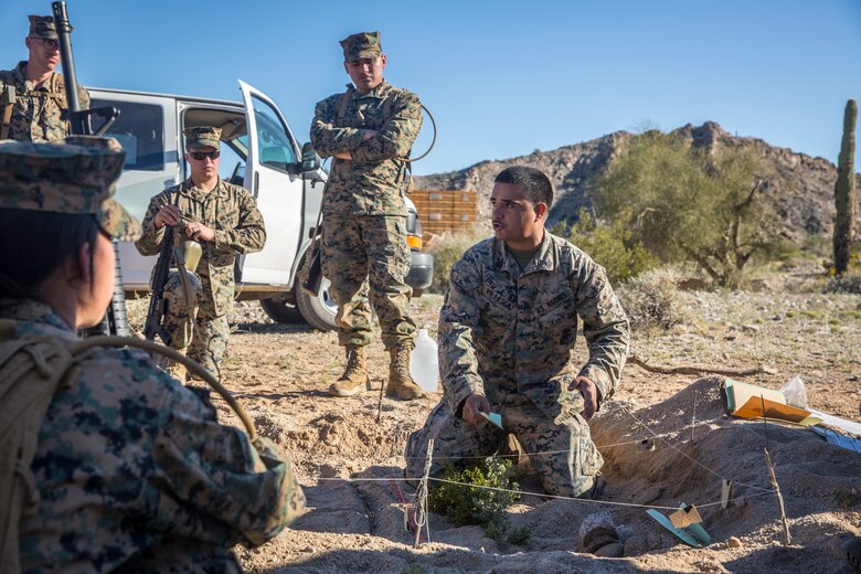 U.S. Marines and Sailors assigned to Marine Corps Air Station (MCAS) Yuma's Search and Rescue (SAR) unit talk about the SAR unit's mission to non-commisioned officers (NCOs) from MCAS Yuma, Ariz., Feb. 7, 2019 as a part of "Operation Backbone." Operation Backbone is a quarterly unit exercise meant to strengthen the warrior's spirit in the non-commisioned officers (NCOs) and promote cohesion between them. The exercise consisted of a hike with the Headquarters and Headquarters Squadron (H&HS)  commanding officer and acting sergeant major, several classes, and a warriors night. Classes included simulated room clearing training, terrain model training, improvised explosive devices (IED) training, and the Family Advocacy Program on station sent out a representative to talk to the NCOs about leadership. (U.S. Marine Corps photo by Cpl. Isaac D. Martinez)