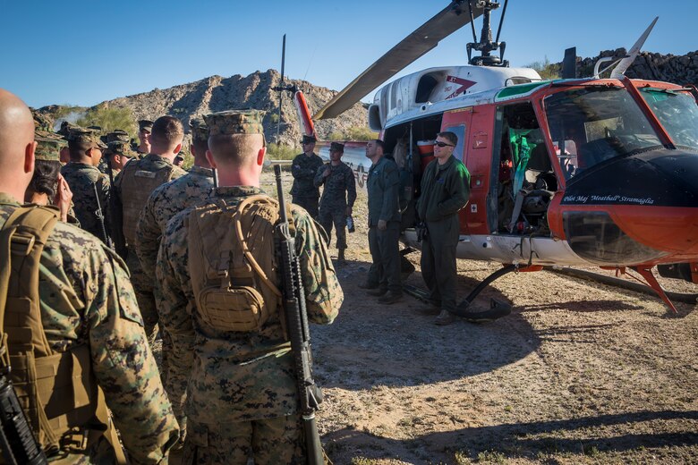 U.S. Marines and Sailors assigned to Marine Corps Air Station (MCAS) Yuma's Search and Rescue (SAR) unit talk about the SAR unit's mission to non-commisioned officers (NCOs) from MCAS Yuma, Ariz., Feb. 7, 2019 as a part of "Operation Backbone." Operation Backbone is a quarterly unit exercise meant to strengthen the warrior's spirit in the non-commisioned officers (NCOs) and promote cohesion between them. The exercise consisted of a hike with the Headquarters and Headquarters Squadron (H&HS)  commanding officer and acting sergeant major, several classes, and a warriors night. Classes included simulated room clearing training, terrain model training, improvised explosive devices (IED) training, and the Family Advocacy Program on station sent out a representative to talk to the NCOs about leadership. (U.S. Marine Corps photo by Cpl. Isaac D. Martinez)