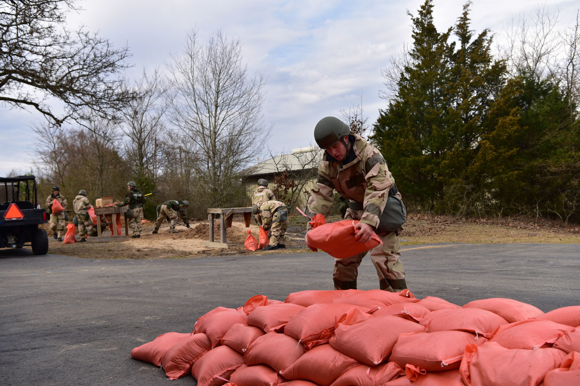Airmen adds sandbag to pile