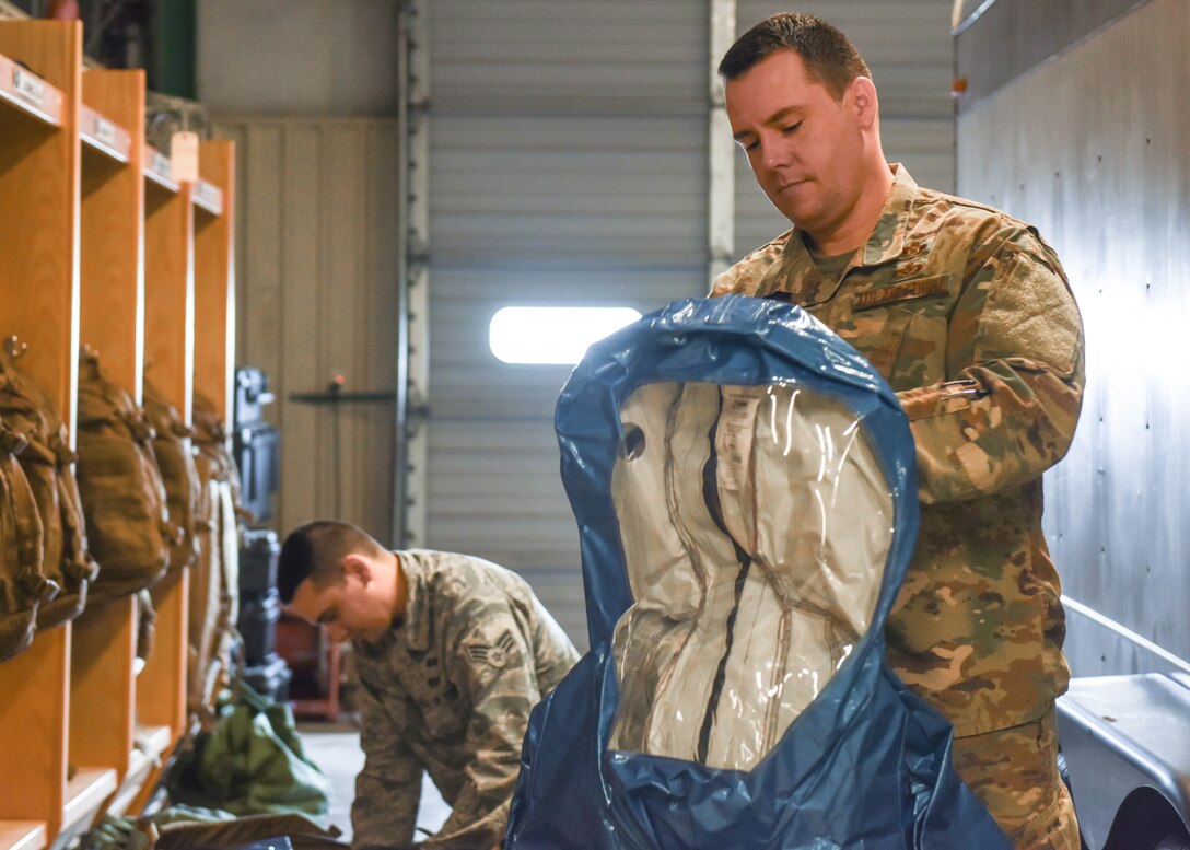Master Sgt. Kevin McGinnis, 14th Civil Engineer Squadron Readiness and Emergency Management Flight superintendent, and Senior Airman Brett Jones, 14th CES Readiness and Emergency Management Flight journeyman, show how to properly put on hazardous material gear Feb. 26, 2019, on Columbus Air Force Base, Mississippi. McGinnis and his team responsible for the base’s emergency planning during natural disasters, chemical, biological, radioactive or nuclear attacks, certain aircraft mishaps, and other incidents. (U.S. Air Force photo by Senior Airman Beaux Hebert