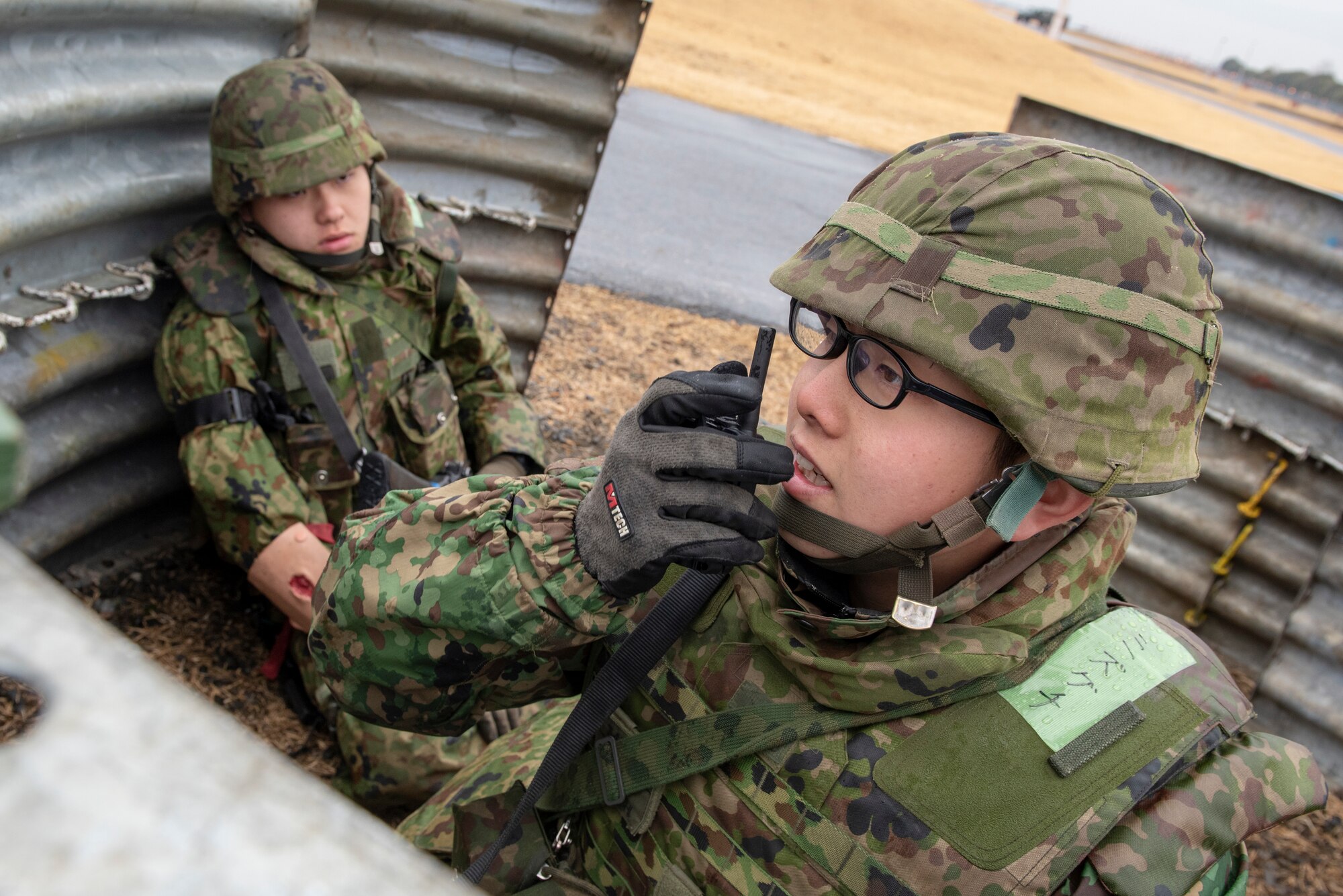 A member of the Japan Ground Self-Defense Force (JGSDF) 34th Infantry Regiment out of Camp Itazuma in Gotemba, Japan, radios in for backup during a sniper fire scenario during Guard and Protect 2019 at Yokota Air Base, Japan, Feb. 27, 2019.