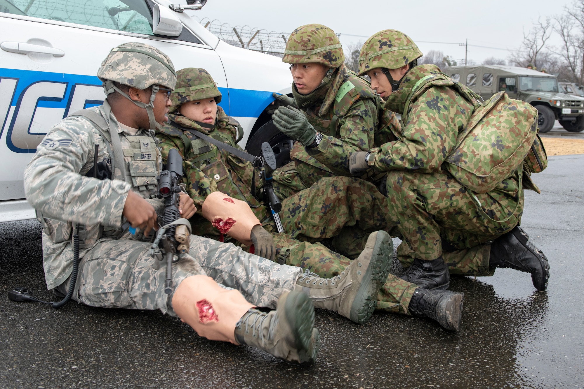 Senior Airman Clifton Carter, 374th Security Forces Squadron patrolman, and members of the Japan Ground Self-Defense Force (JGSDF) from the 34th Infantry Regiment out of Camp Itazuma in Gotemba, Japan discuss a plan of attack during the sniper fire portion of Guard and Protect 2019 at Yokota Air Base, Japan, Feb. 28, 2019.