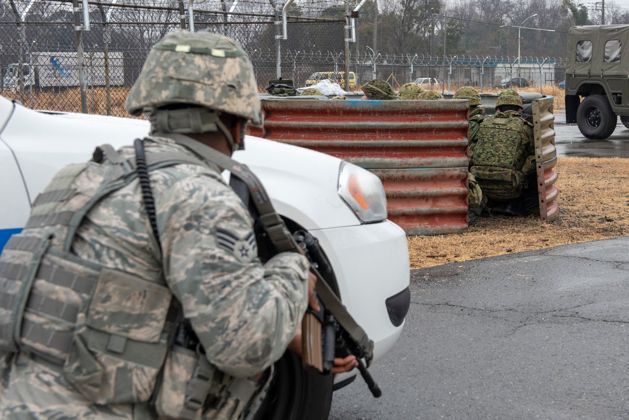 Senior Airman Clifton Carter, 374th Security Forces Squadron patrolman, arrives in response to a request for backup from Japan Ground Self-Defense Force (JGSDF) personnel from the 34th Infantry Regiment out of Camp Itazuma in Gotemba, Japan, during a sniper fire scenario during Guard and Protect 2019 at Yokota Air Base, Japan, Feb. 28, 2019.