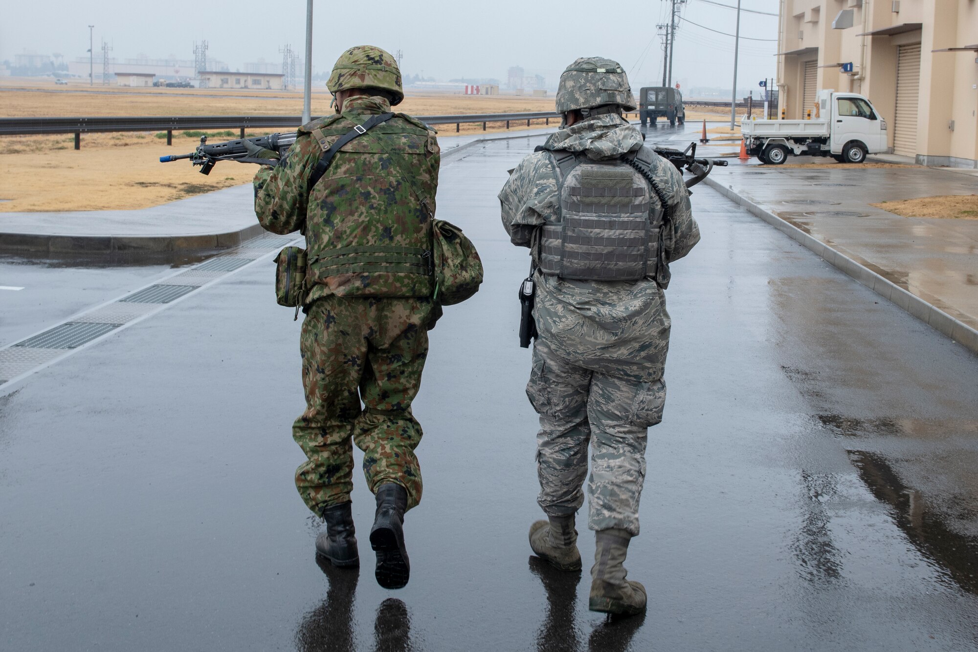 Members of the 374th Security Forces Squadron and Japan Ground Self-Defense Force (JGSDF) 34th Infantry Regiment out of Camp Itazuma in Gotemba, Japan, scan the area in pursuit of an intruder during Guard and Protect 2019 at Yokota Air Base, Japan, Feb. 28, 2019.