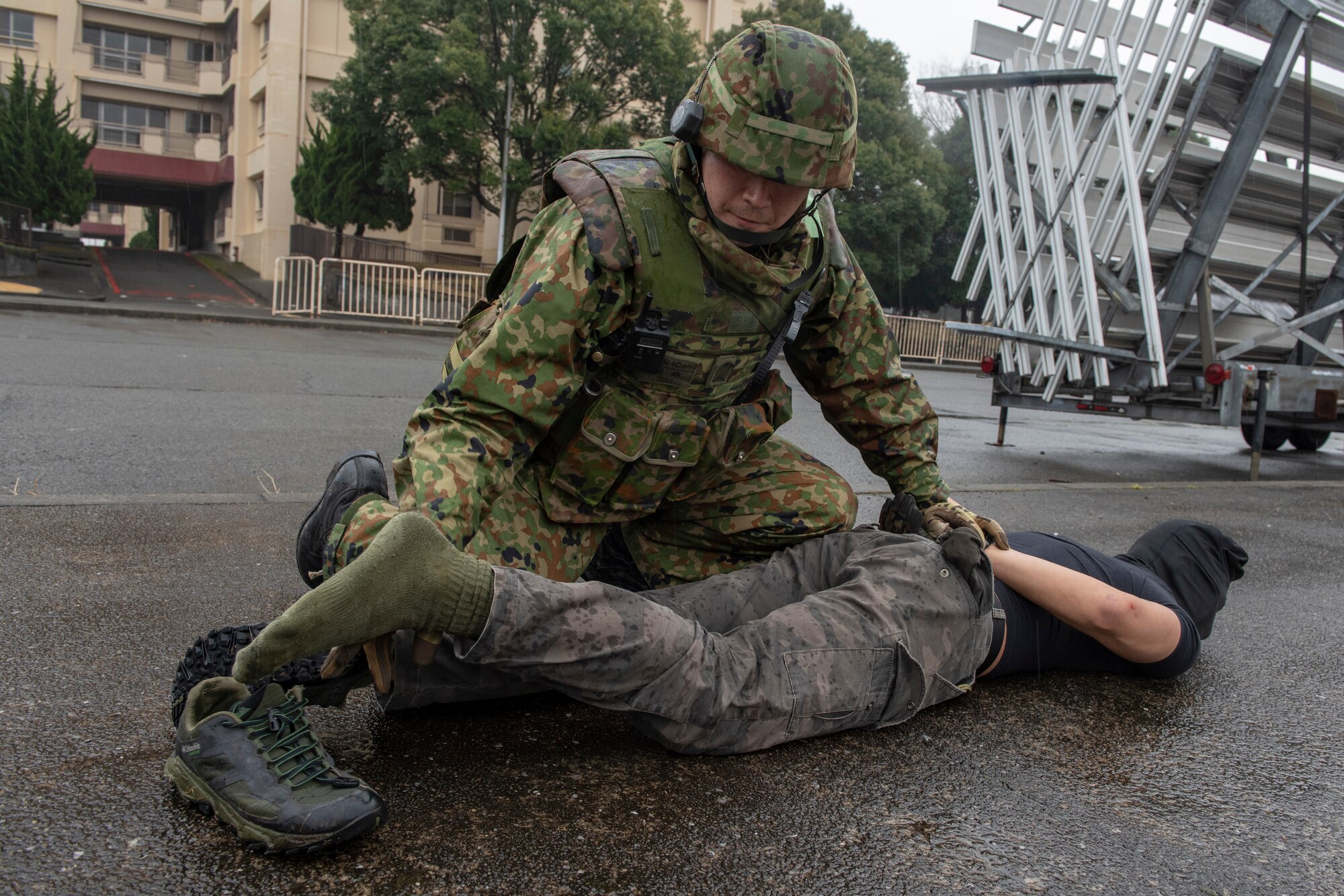 A member of the Japan Ground Self-Defense Force (JGSDF) 34th Infantry Regiment out of Camp Itazuma in Gotemba, Japan conducts a search on a detainee after working with 374th Security Forces Squadron to secure an area during Guard and Protect 2019 at Yokota Air Base, Japan, Feb. 28, 2019.