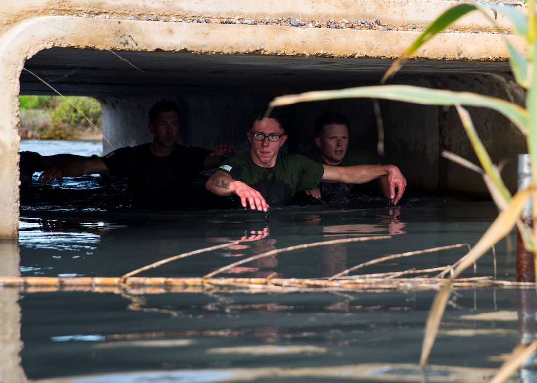 U.S. Marines with Special Purpose Marine Air-Ground Task Force-Crisis Response-Africa swim through a passageway while competing in an 8K race with Spanish soldiers in San Fernando, Spain, Dec. 19, 2018.