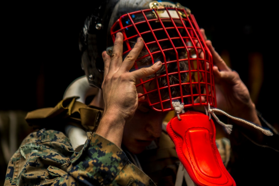 U.S. Marine Cpl. Isaiah Chavez, a heavy equipment mechanic with Combat Logistics Battalion 13, 13th Marine Expeditionary Unit, removes a helmet during the culminating event of a Marine Corps Martial Arts Program instructor course, aboard the Wasp-class amphibious assault ship USS Essex, Dec. 27, 2018. The Essex is the flagship for the Essex Amphibious Ready Group and, with the embarked 13th MEU, is deployed to the U.S. 5th Fleet area of operations in support of naval operations to ensure maritime stability and security in the Central Region, connecting the Mediterranean and the Pacific through the western Indian Ocean and three strategic choke points.