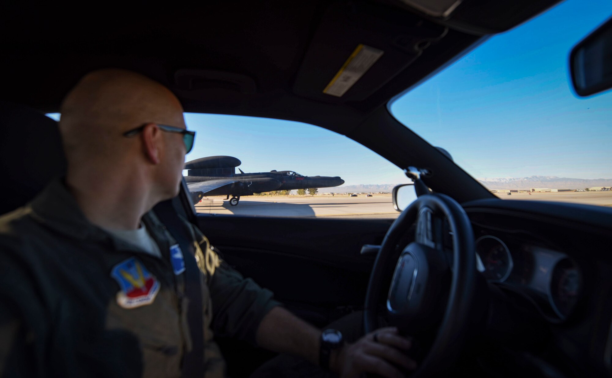 A pilot looks out of the window of a car to observe a U-2 aircraft.