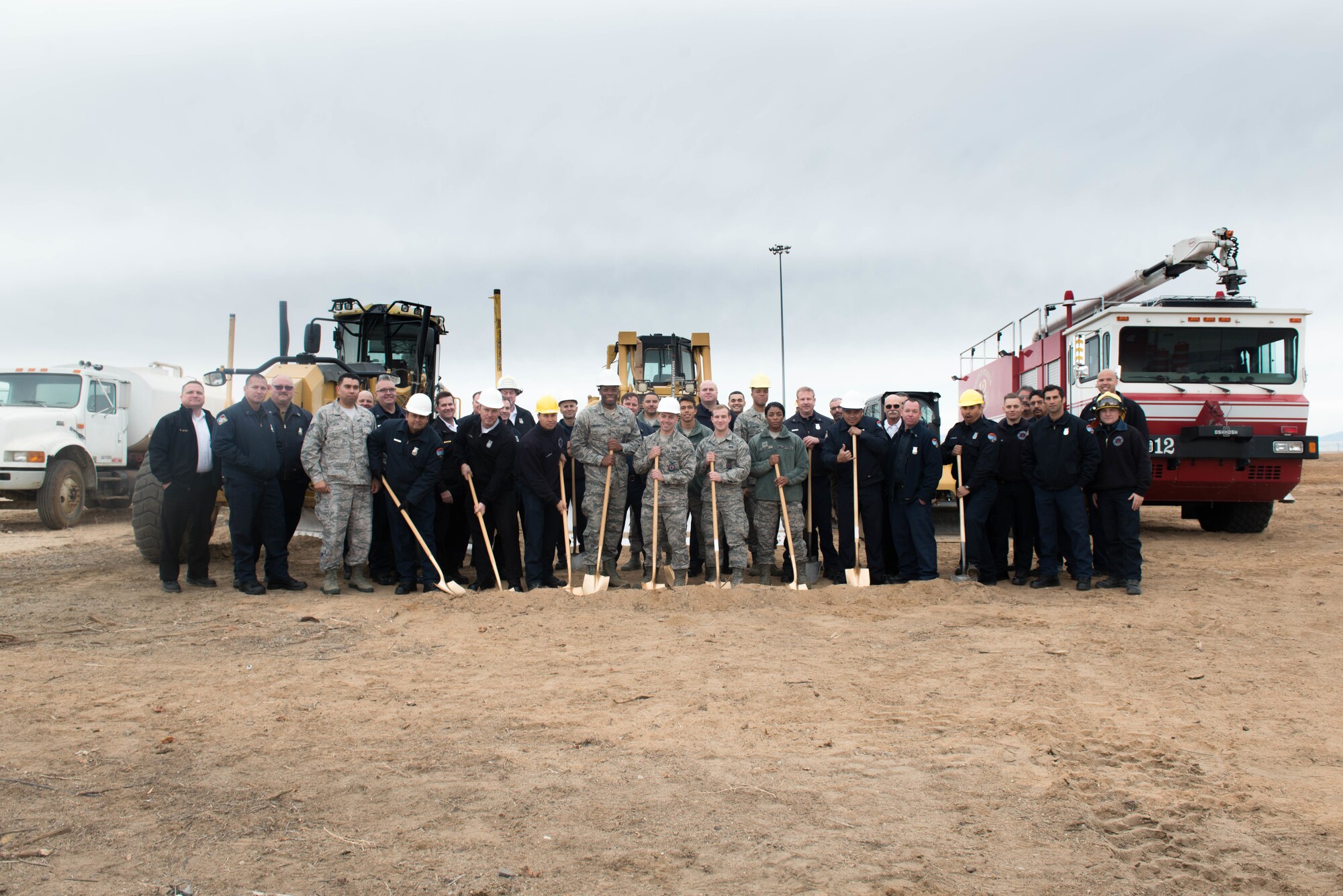 Members of the 812th Civil Engineer Squadron and its firefighters, pose for a ceremonial ground breaking photo Dec. 14, 2018, where a new fire station will be constructed on the flightline. (U.S. Air Force photo by Joe Jones)