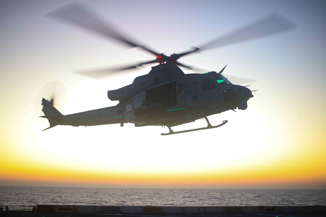 A helicopter departs a flight deck.