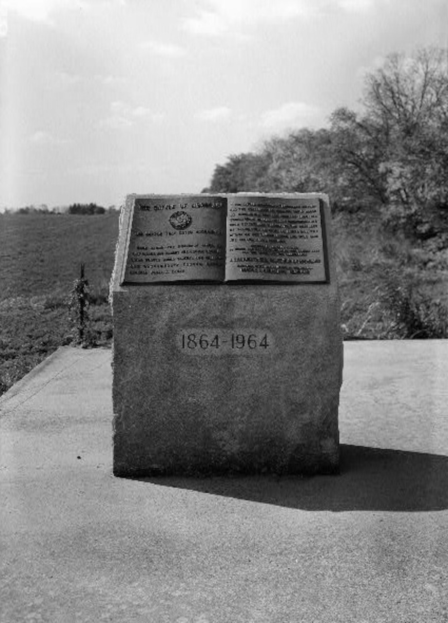 A stone monument on a field with inscription regarding the Monocacy Battle.