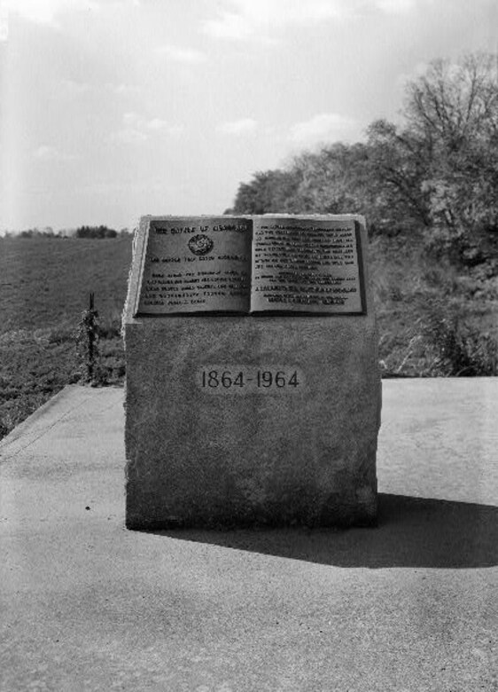 A stone monument on a field with inscription regarding the Monocacy Battle.