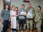 Brig. Gen. George N. Appenzeller (second from left), Brooke Army Medical Center commander, along with Sarah Kelly (far left), BAMC auxiliary president, and Master Sgt. Melinda Griffin (far right), enlisted advisor to the deputy chief for patient support, present a gift basket to retired Army Sgt. Christopher and Hillary Hunt after the birth of their son, Callum Charles Hunt, at Brooke Army Medical Center at Joint Base San Antonio-Fort Sam Houston Jan. 2, 2019. Callum, born at 1:50 a.m. on New Year’s Day, was BAMC first baby born in 2019.