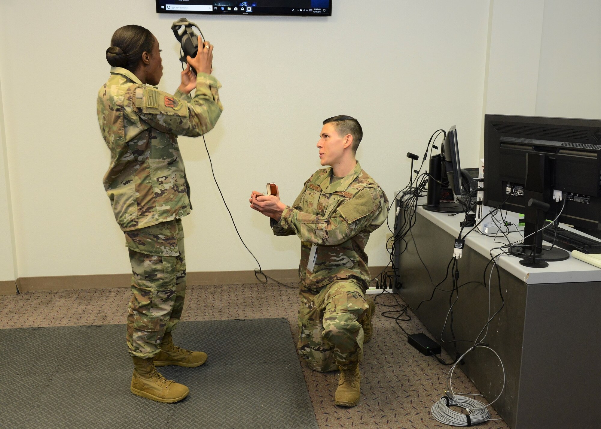 On one knee, Tech. Sgt. Jeremy Neilson, 412th Aircraft Maintenance Squadron, proposes to Staff Sgt. Nori Sannoh following a presentation to base leadership on using virtual reality programs to train F-35 maintenance personnel Dec. 20, 2018. (U.S. Air Force photo by Kenji Thuloweit)