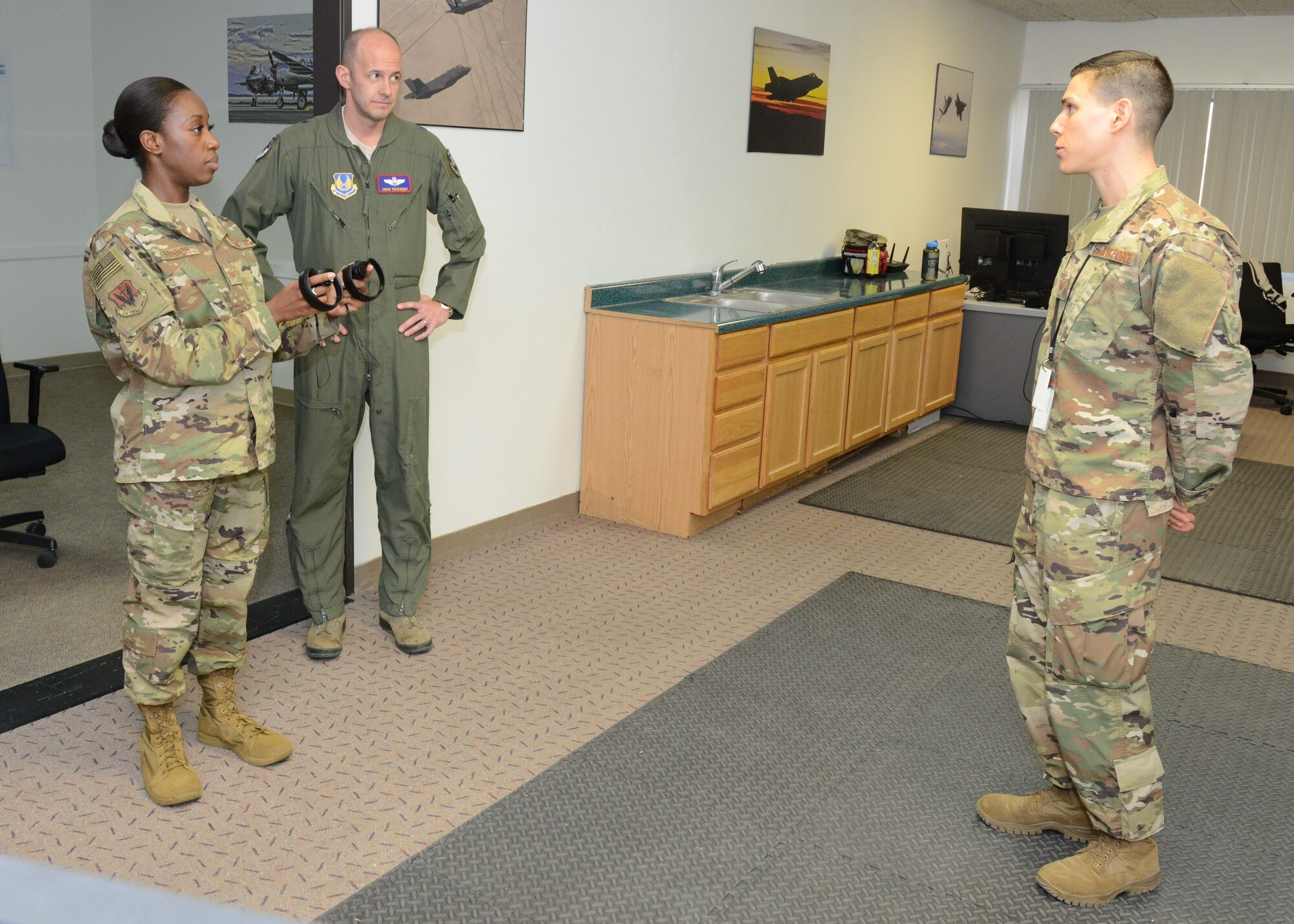 Tech. Sgt. Jeremy Neilson, 412th Aircraft Maintenance Squadron (right), and Staff Sgt. Nori Sannoh, 432nd Maintenance Group, Nellis Air Force Base, Nevada, discuss using virtual reality programs for training with Brig. Gen. E. John Teichert, 412th Test Wing commander, Dec. 20, 2018. (U.S. Air Force photo by Kenji Thuloweit)