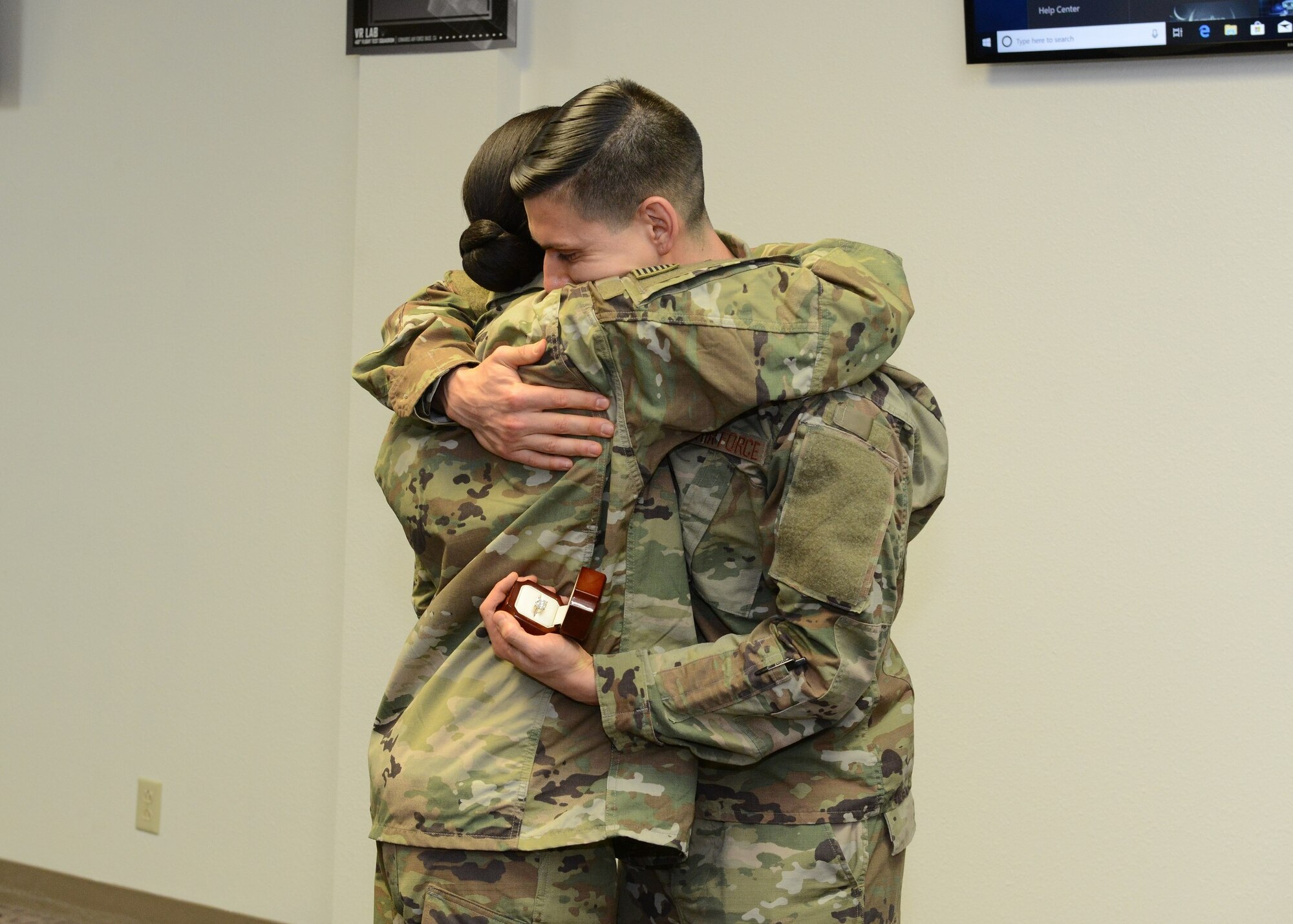 Tech. Sgt. Jeremy Neilson, 412th Aircraft Maintenance Squadron, hugs Staff Sgt. Nori Sannoh, 432nd Maintenance Group, Nellis Air Force Base, Nevada, after he surprised her with a marriage proposal Dec. 20, 2018. (U.S. Air Force photo by Kenji Thuloweit)