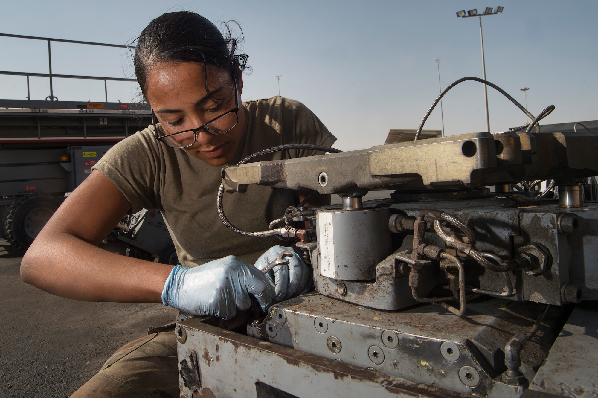 Airman 1st Class Annaliz Rodriguez, 379th Expeditionary Maintenance Squadron aerospace ground equipment (AGE) journeyman, fixes a leak found during routine maintenance for a bomb lift Jan. 4, 2018, at Al Udeid Air Base, Qatar. AGE Airmen here perform maintenance on a variety of aircraft equipment including bomb lifts, hydraulic test stands, air conditioners, heaters and power carts. (U.S. Air Force photo by Tech. Sgt. Christopher Hubenthal)
