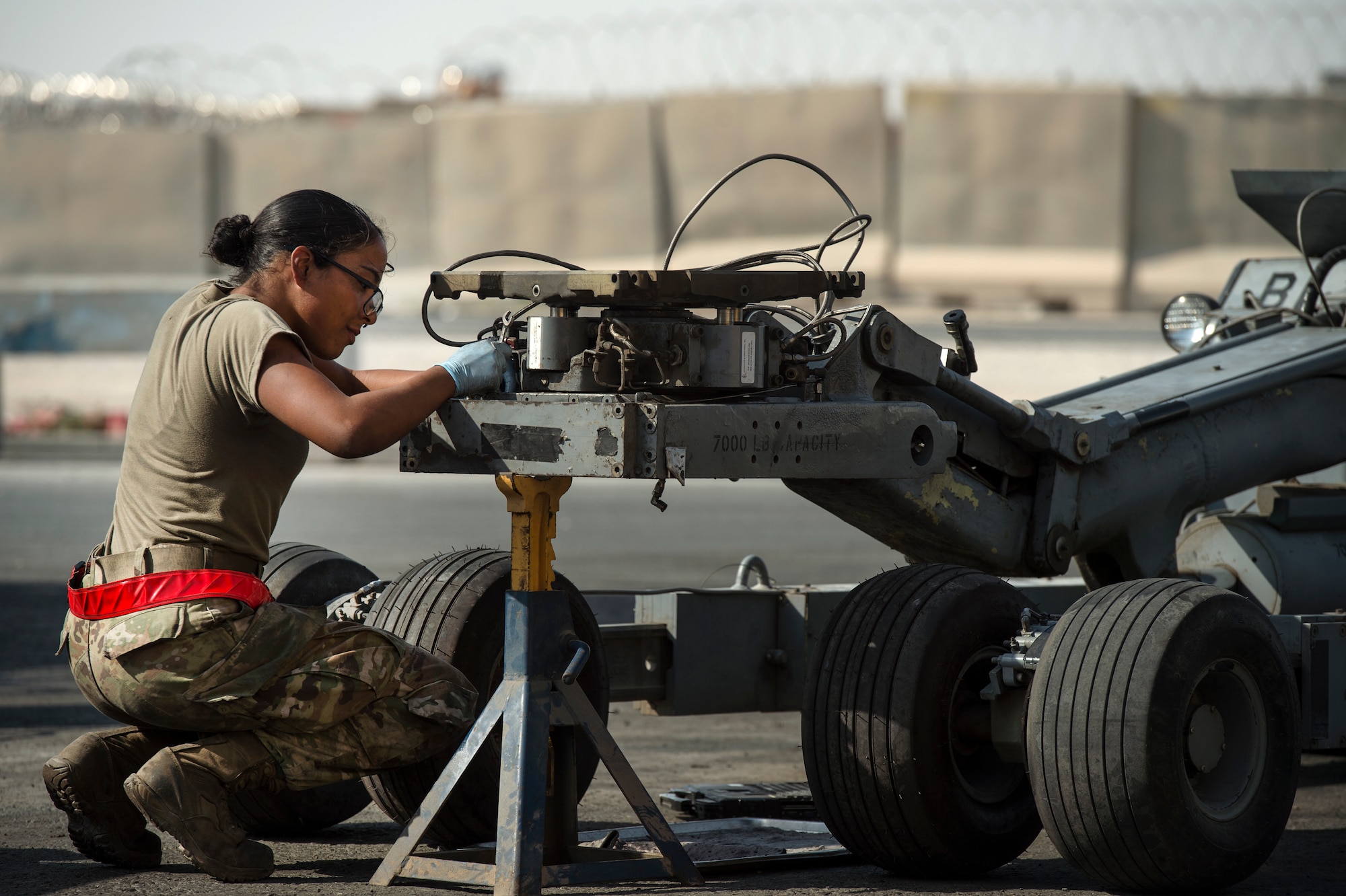 Airman 1st Class Annaliz Rodriguez, 379th Expeditionary Maintenance Squadron aerospace ground equipment (AGE) journeyman, fixes a leak found during routine maintenance for a bomb lift Jan. 4, 2018, at Al Udeid Air Base, Qatar. AGE Airmen here perform maintenance on a variety of aircraft equipment including bomb lifts, hydraulic test stands, air conditioners, heaters and power carts. (U.S. Air Force photo by Tech. Sgt. Christopher Hubenthal)