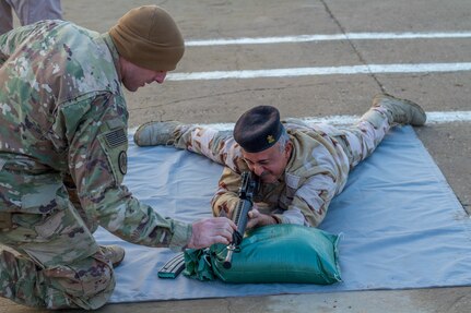 U.S. Army Spc. Matthew Driskill, left, a cavalry scout assigned to Task Force India Bravo, assists an Iraqi soldier with a dime/washer drill as part of a primary marksmanship instruction course at Camp Taji, Iraq, Dec.19, 2018. Task Force India Bravo is comprised of Soldiers from 1st Squadron, 98th Cavalry Regiment, 106th Support Battalion and 2nd Battalion, 114th Field Artillery Regiment, 155th Armored Brigade Combat Team, Mississippi Army National Guard, and is deployed in support of Combined Joint Task Force – Operation Inherent Resolve, working with the Iraqi Security Forces to develop a sustainable and inclusive force that can secure its sovereign borders, protect the population, and ensure the lasting defeat of ISIS.