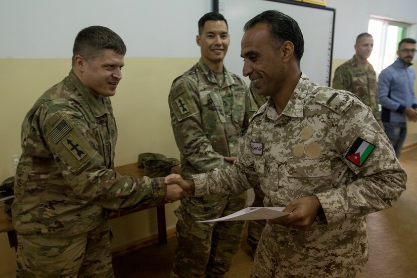 U.S. Army Staff Sergeant Christopher Reitz, with the 157th Military Engagement Team, Wisconsin Army National Guard, shakes hands with Warrant Officer 1 Khaled Hassan Salah, an instructor with the Jordan Armed Forces, at a ceremony to celebrate the completion of a joint course on methods of instruction, Dec. 18, 2018, at the Jordanian noncommissioned officer academy near the Joint Training Center, Jordan. Sharing knowledge through collaborative meetings with partner nation forces increases interoperability and a shared understanding of noncommissioned officer professional development.