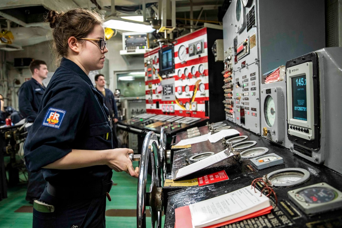 A sailor adjusts the rotations of a ship's shaft.