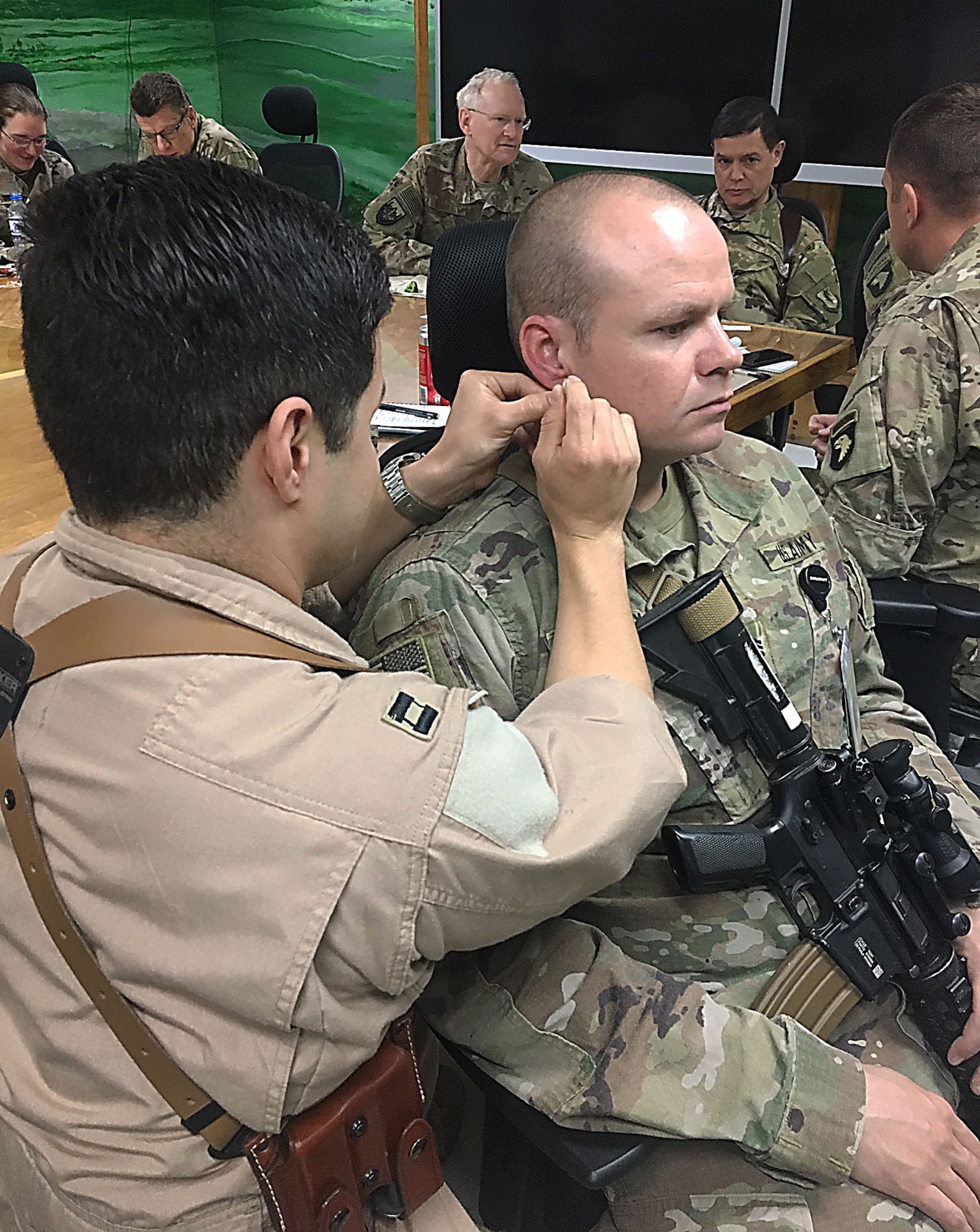 Air Force Capt. Christopher Sandoval places a needle in the outer ear of Army Sgt. 1st Class David Ussery during a four-hour Battlefield Acupuncture class given Nov.18 at Craig Joint Theater Hospital certifying an additional 12 providers.