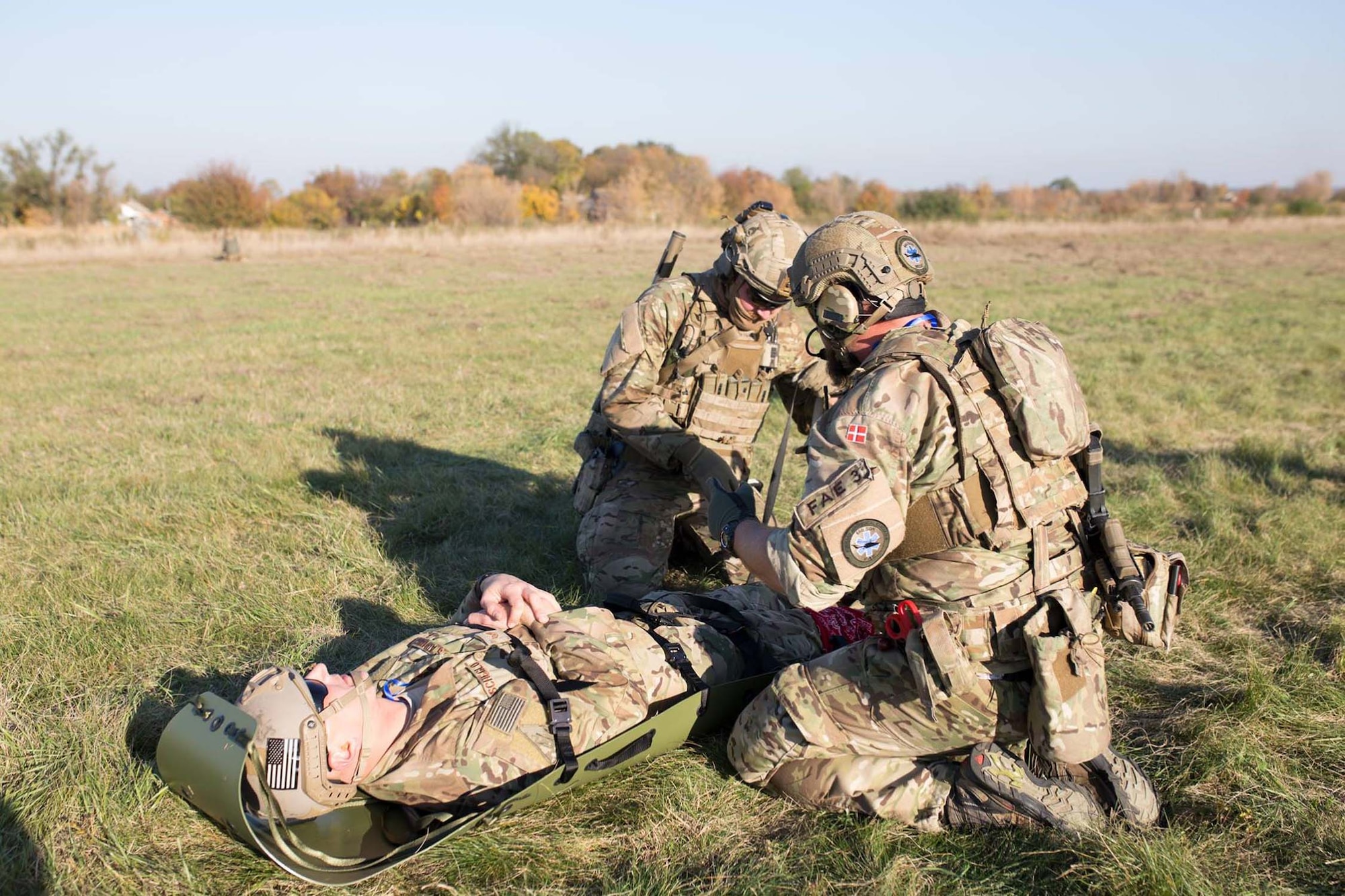 Danish pararescuemen secure Staff Sgt. Mikhail Scheglov, a finance technician with the 141st Comptroller Flight, to a stretcher during a training exercise during Clear Sky 2018 Oct. 16, 2018 at Vinnytsia Air Base, Ukraine. Clear Sky was a multi-national exercise aimed to promote peace, security and interoperability between regional allies as well as NATO partners. The two-week exercise brought together nearly 1,000 military personnel from nine countries. (U.S. Air National Guard photo by Staff Sgt. Brian Jarvis)