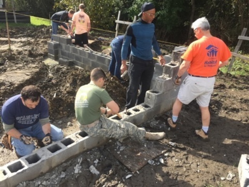 Space and Naval Warfare Systems Center (SSC) Atlantic New Professionals (NPs) help lay the foundation for a new Habitat for Humanity home.