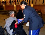 Rebecca Oduba, left, grandmother of Army Lt. Col. Thomas E. Wooden Jr., receives an American flag in honor of her grandson's retirement Jan. 4, 2018 in Philadelphia.