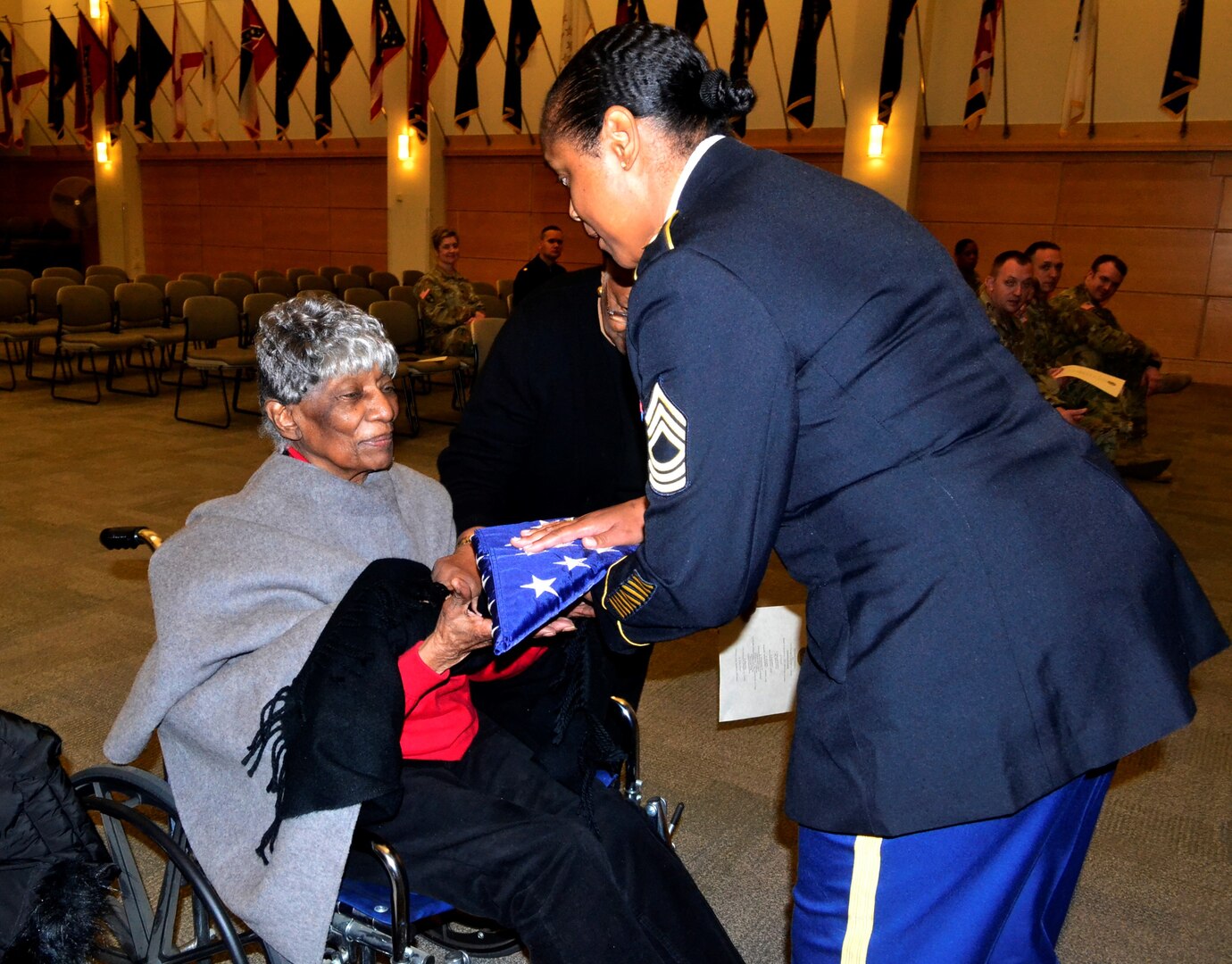 Rebecca Oduba, left, grandmother of Army Lt. Col. Thomas E. Wooden Jr., receives an American flag in honor of her grandson's retirement Jan. 4, 2018 in Philadelphia.