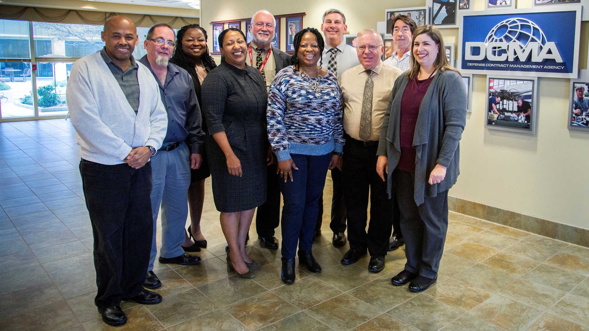 Group of people stand in front of a DCMA sign.