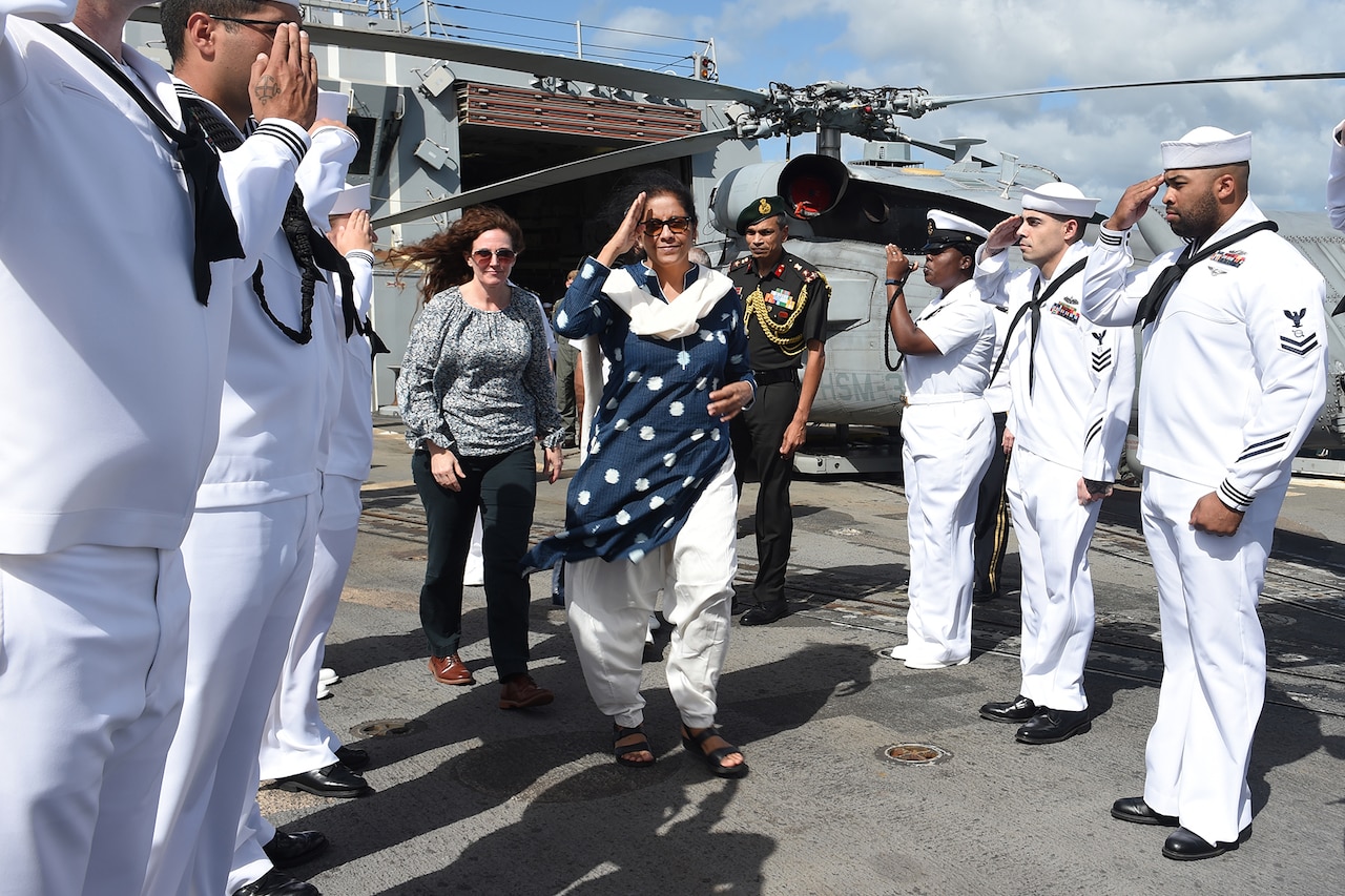 Sailors salute a dignitary.