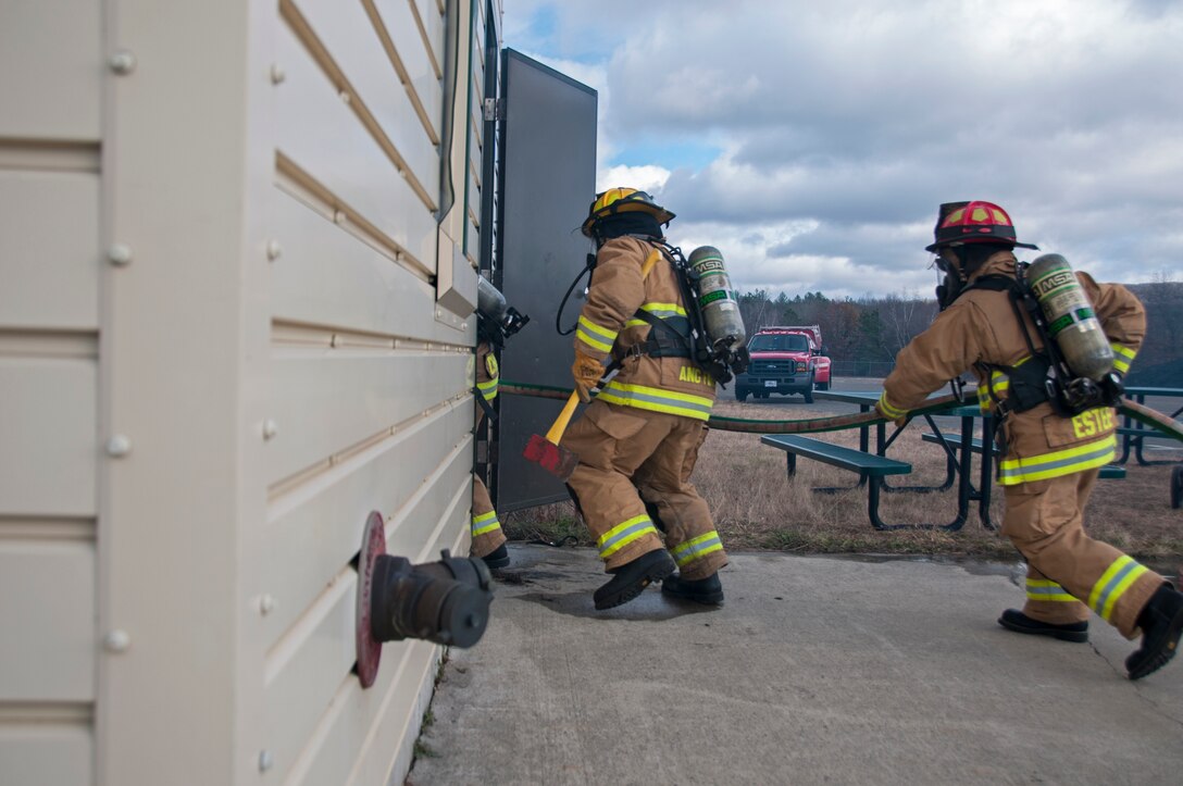 Airman 1st Class Shawn Burgmyer, 104th Civil Engineering Squadron firefighter, and Lt. Dan Estee, 104th CES shift officer, particpiate in live structural fire training Nov. 27, 2018, at Barnes Air National Guard Base, Massachusetts. The training ensures the Fire Attack Teams are prepared to respond to any fires on base or in the surrounding communities. (U.S. Air National Guard photo by Airman 1st Class Randy Burlingame)