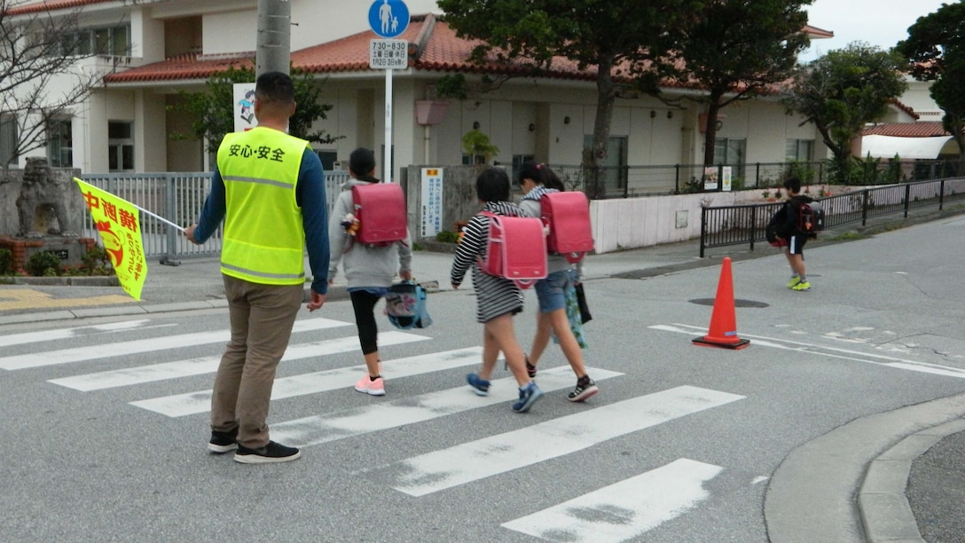 海兵隊員が小学校前の横断歩道で子どもたちの安全を見守る