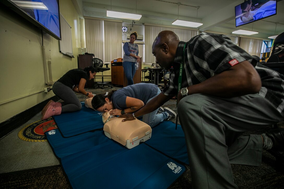 Terri Watkins (right), the director of Marine Corps Base Hawaii (MCBH) Base Safety, helps a Mokapu Elementary School staff member during a First Aid training class, MCBH, Jan. 4, 2019. The class provided cardiopulmonary resuscitation, first aid, and automated external defibrillator training to the school staff to ensure the safety and well-being of all students at Mokapu Elementary School. (U.S. Marine Corps photo by Cpl. Matthew Kirk)