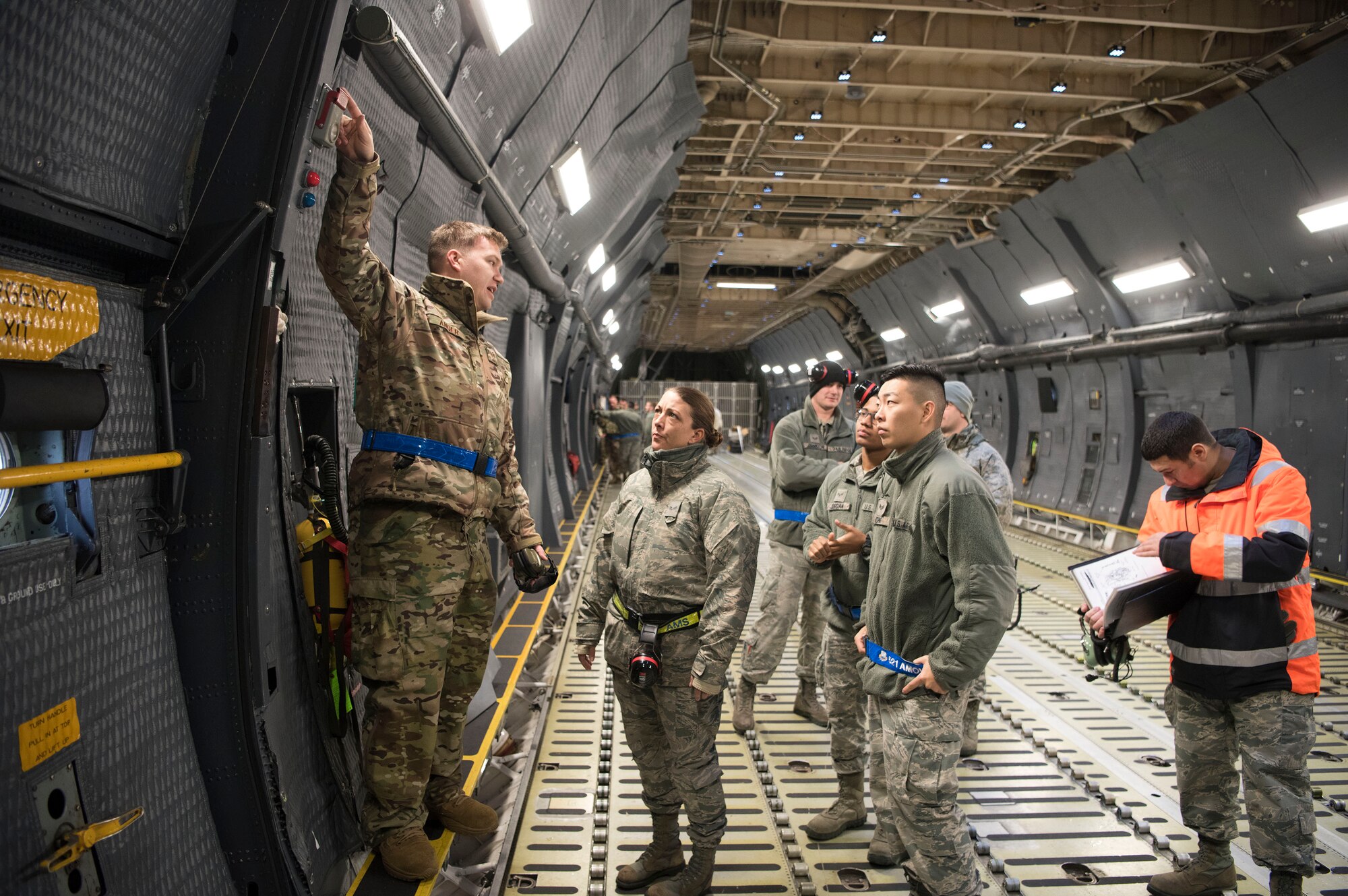 U.S. Air Force Staff Sgt. Brett Anger, 521st Air Mobility Operations Wing electrical and environmental systems instructor, shows Airmen where the safety wire is located on the emergency pull-light, which indicates the system has not been tampered with, Dec. 3, 2018, on Ramstein Air Base, Germany. This task was one of the approximately 1,000 tasks 141 students learned and trained on throughout the two week training exercise. (U.S. Air Force photo by Airman 1st Class Kristof J. Rixmann)
