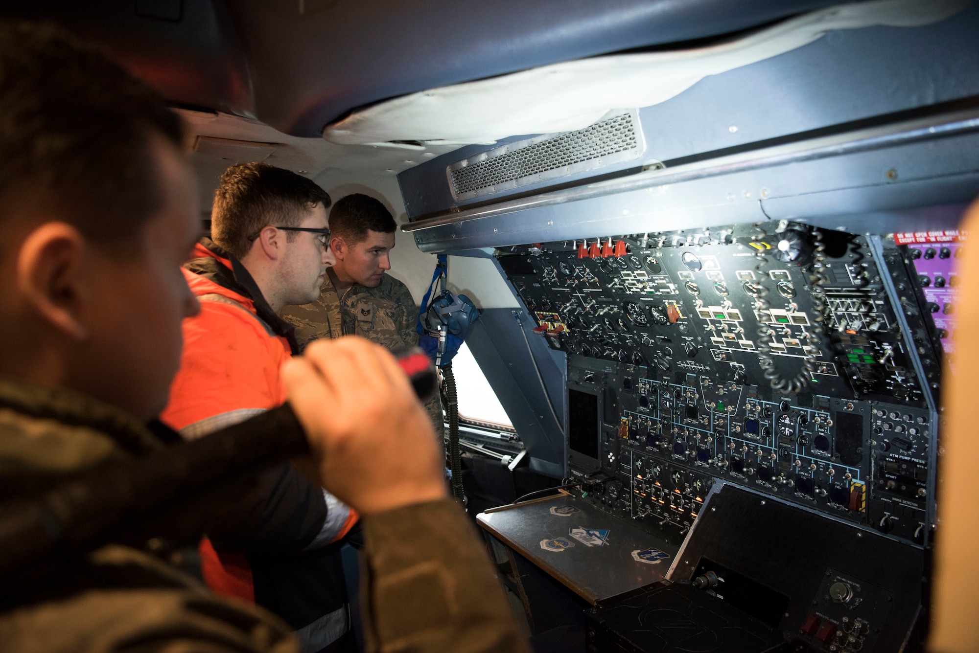 U.S. Air Force Staff Sgt. Ryan Johnson, 521st Air Mobility Operations Wing regional training center crew chief, illuminates part of the cockpit in the C-5M Super Galaxy aircraft while he quizzes Airmen on running auxiliary power units Dec. 3, 2018, on Ramstein Air Base, Germany. The Airmen in this course belonged to the 725th Aircraft Maintenance Squadron from Naval Station Rota, Spain and the 726th AMS from Spangdahlem Air Base, Germany. (U.S. Air Force photo by Airman 1st Class Kristof J. Rixmann)