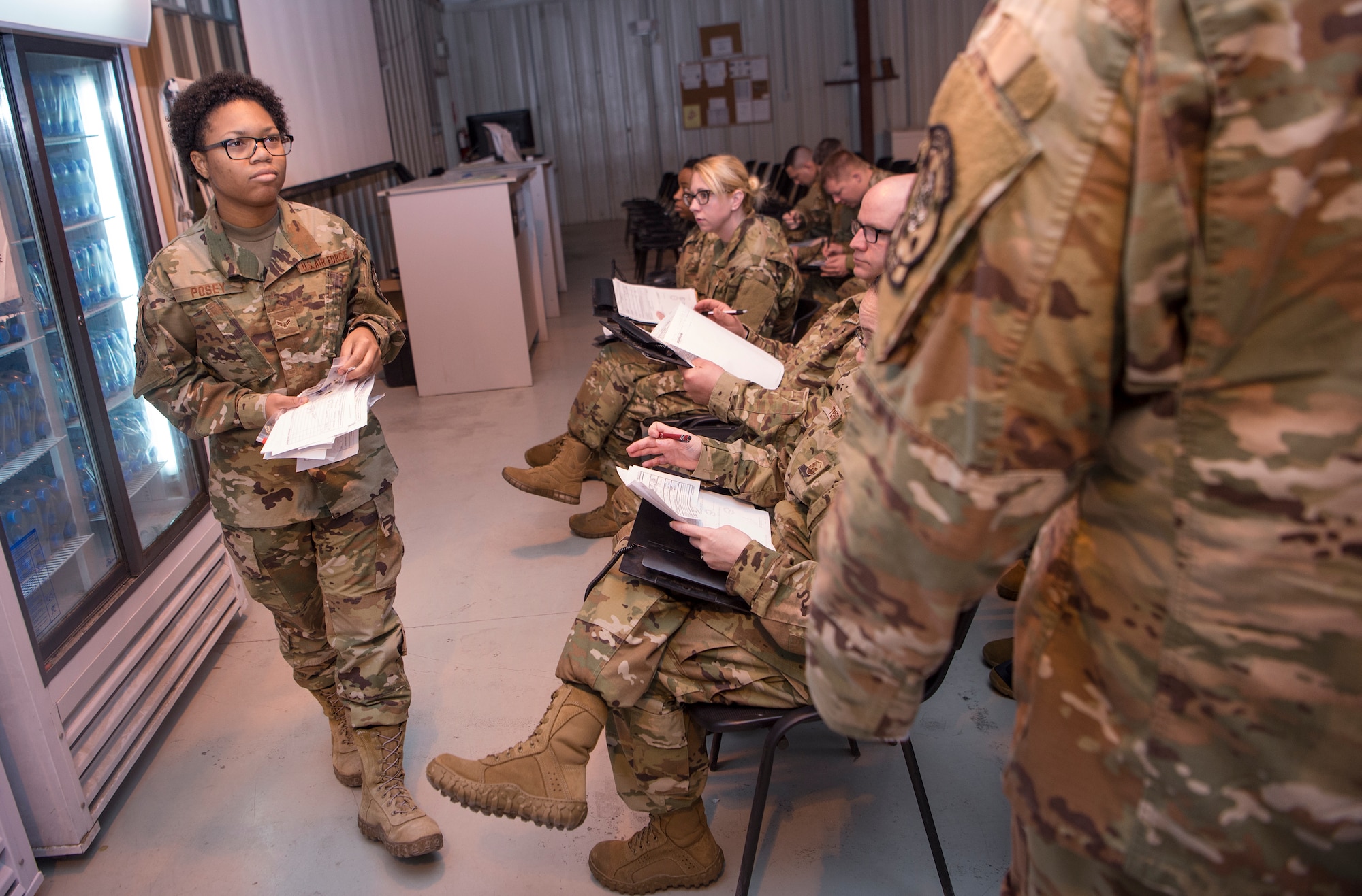 Airman 1st Class Dakaysiah Posey, 379th Expeditionary Logistics Readiness Squadron (ELRS) Air Force Transient Reception Control Center logistics planner, hands out documents to Airmen who just arrived at Al Udeid Air Base, Qatar, Jan. 5, 2019. 379th ELRS log planners relay transportation information to service members traveling to deployed locations across U.S. Central Command’s area of responsibility. They provide warfighters in transition support including lodging, means of communication and vehicles to ensure mission effectiveness as they wait for forward deployment.  (U.S. Air Force photo by Tech. Sgt. Christopher Hubenthal)