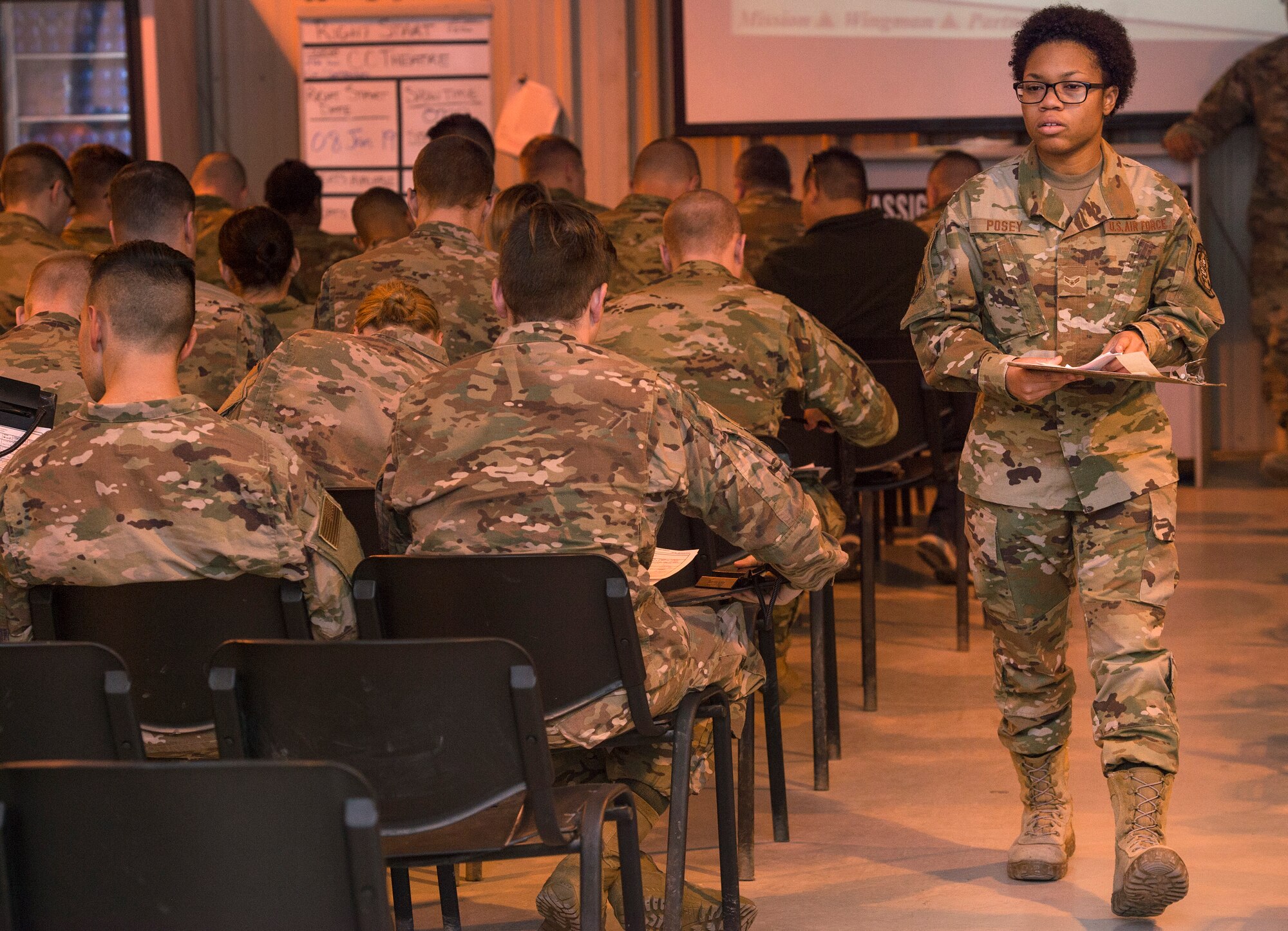 Airman 1st Class Dakaysiah Posey, 379th Expeditionary Logistics Readiness Squadron (ELRS) Air Force Transient Reception Control Center logistics planner, conducts an accountability check and hands out documents to Airmen at Al Udeid Air Base, Qatar, Jan. 5, 2019. 379th ELRS log planners relay transportation information to service members traveling to deployed locations across U.S. Central Command’s area of responsibility. They provide warfighters in transition support including lodging, means of communication and vehicles to ensure mission effectiveness as they wait for forward deployment.  (U.S. Air Force photo by Tech. Sgt. Christopher Hubenthal)