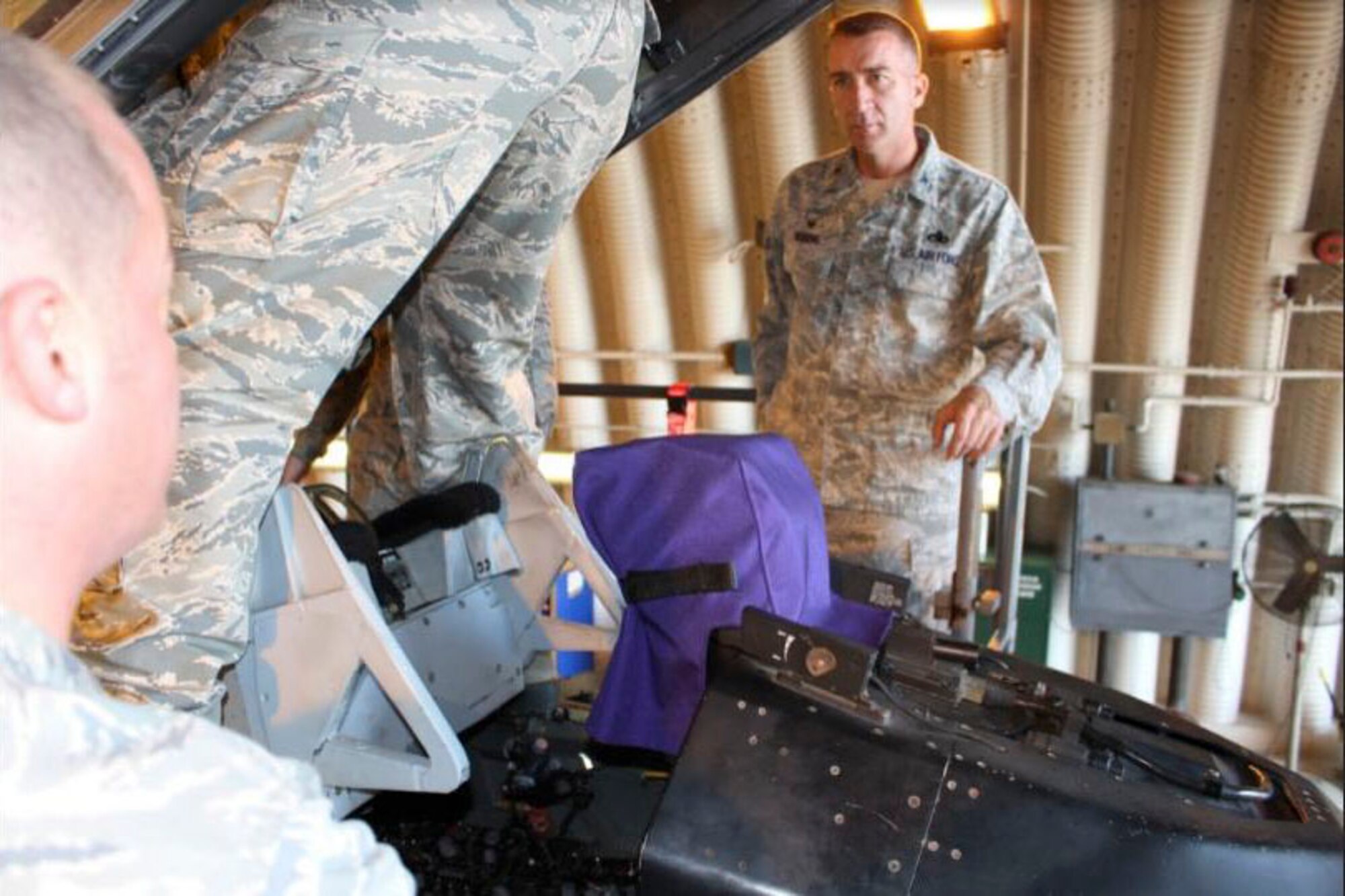 U.S. Air Force Col. Chris Boring, 31st Maintenance Group commander, Aviano Air Base, Italy, listens while Tech. Sgt. Jonathan Marks, 31MXG Egress Technician briefs him on the first ever "Super Raise" procedure. (U.S. Air Force Courtesy Photo)