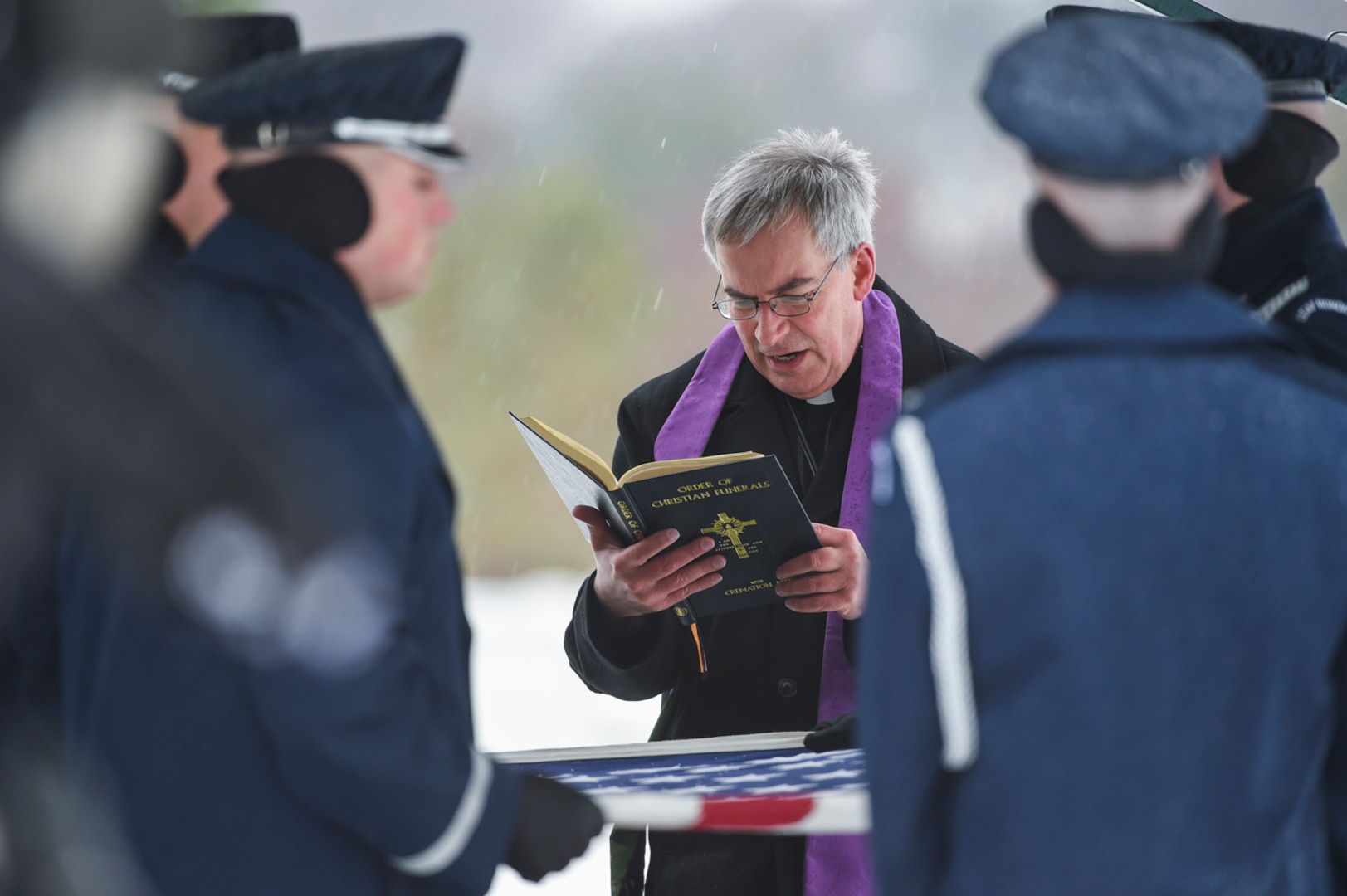 A priest presides over the graveside burial of Chief Master Sgt. Therese Henrion, Nov 15, 2018, at Arlington National Cemetery.